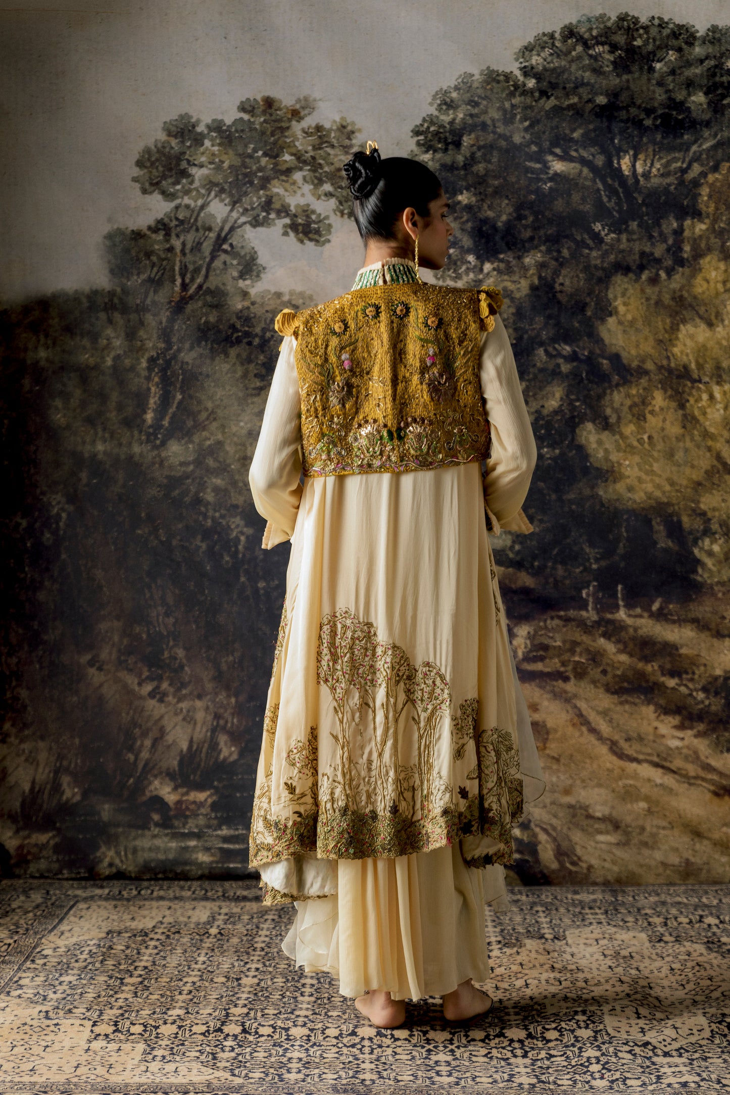 Back view of the Rumi Gown with cape and cropped jacket, showcasing the gown's silhouette and the elegant cape design