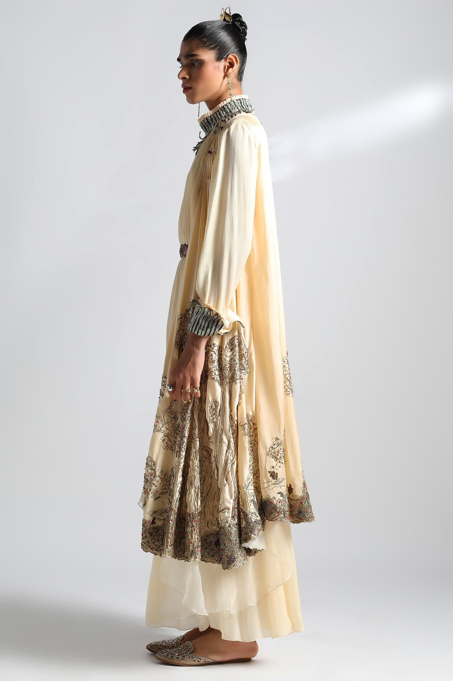 Side view of the Rumi Gown with cape, showcasing the flowing silhouette and detailed embroidery