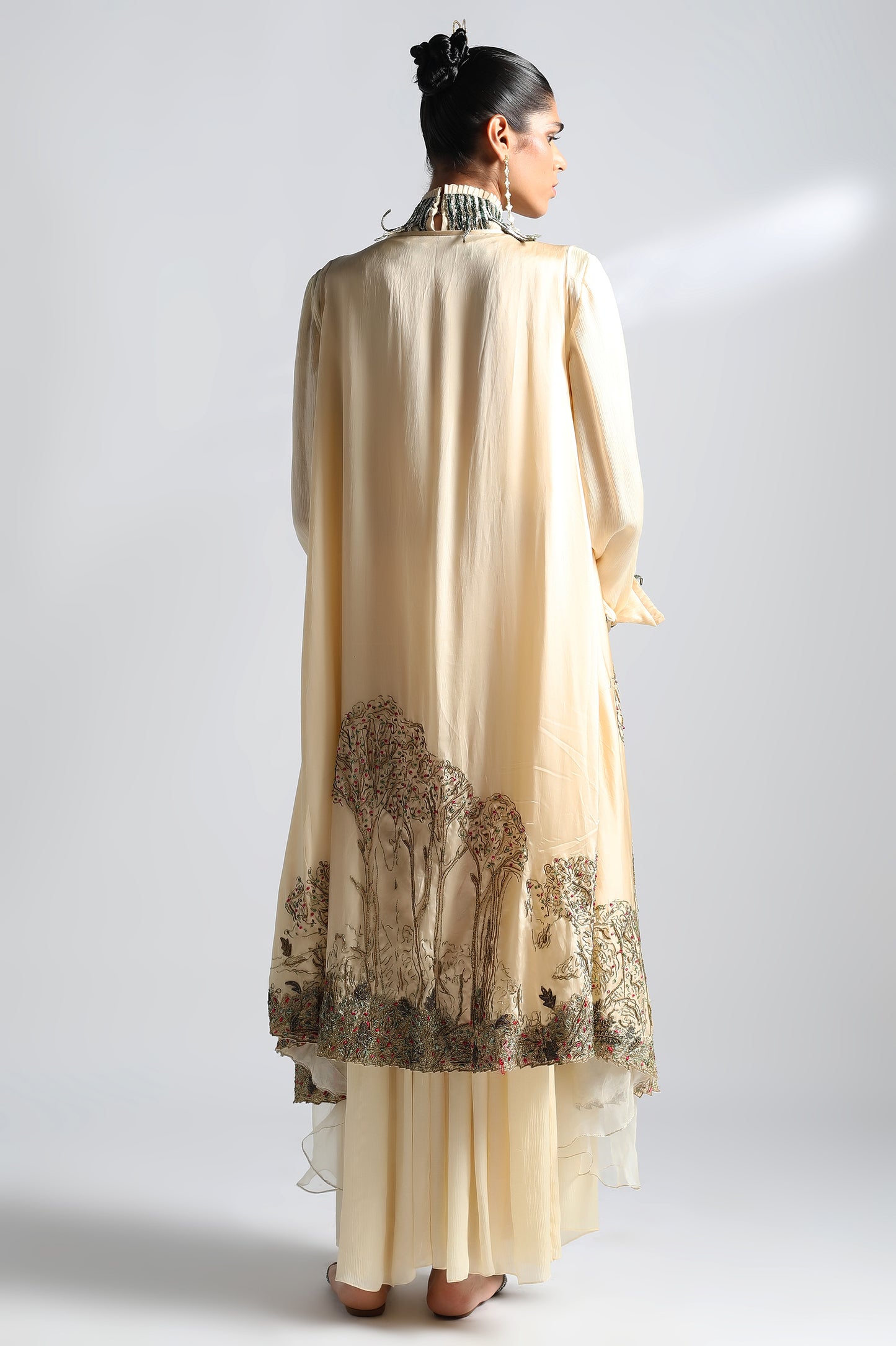 Back view of the Rumi Gown with cape, focusing on the gown's fit and cape design