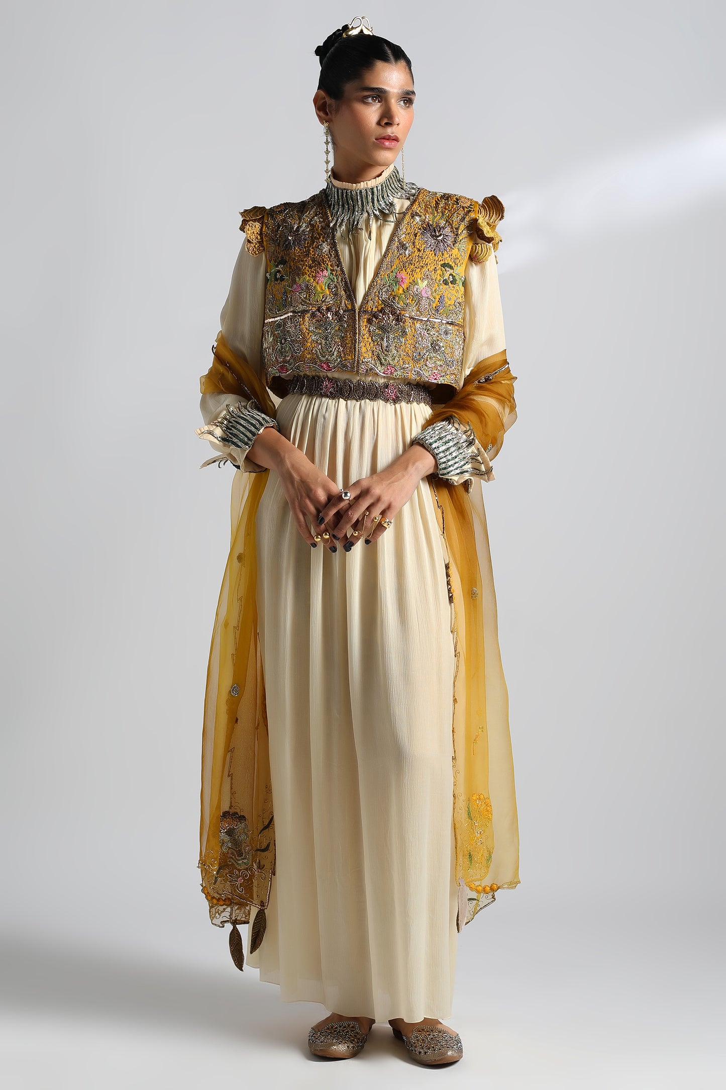 Rumi Gown with Cropped Jacket, Dupatta, and Belt featuring metallic embroidery and intricate handwork, showcasing a gown with a cape and elegant detailing