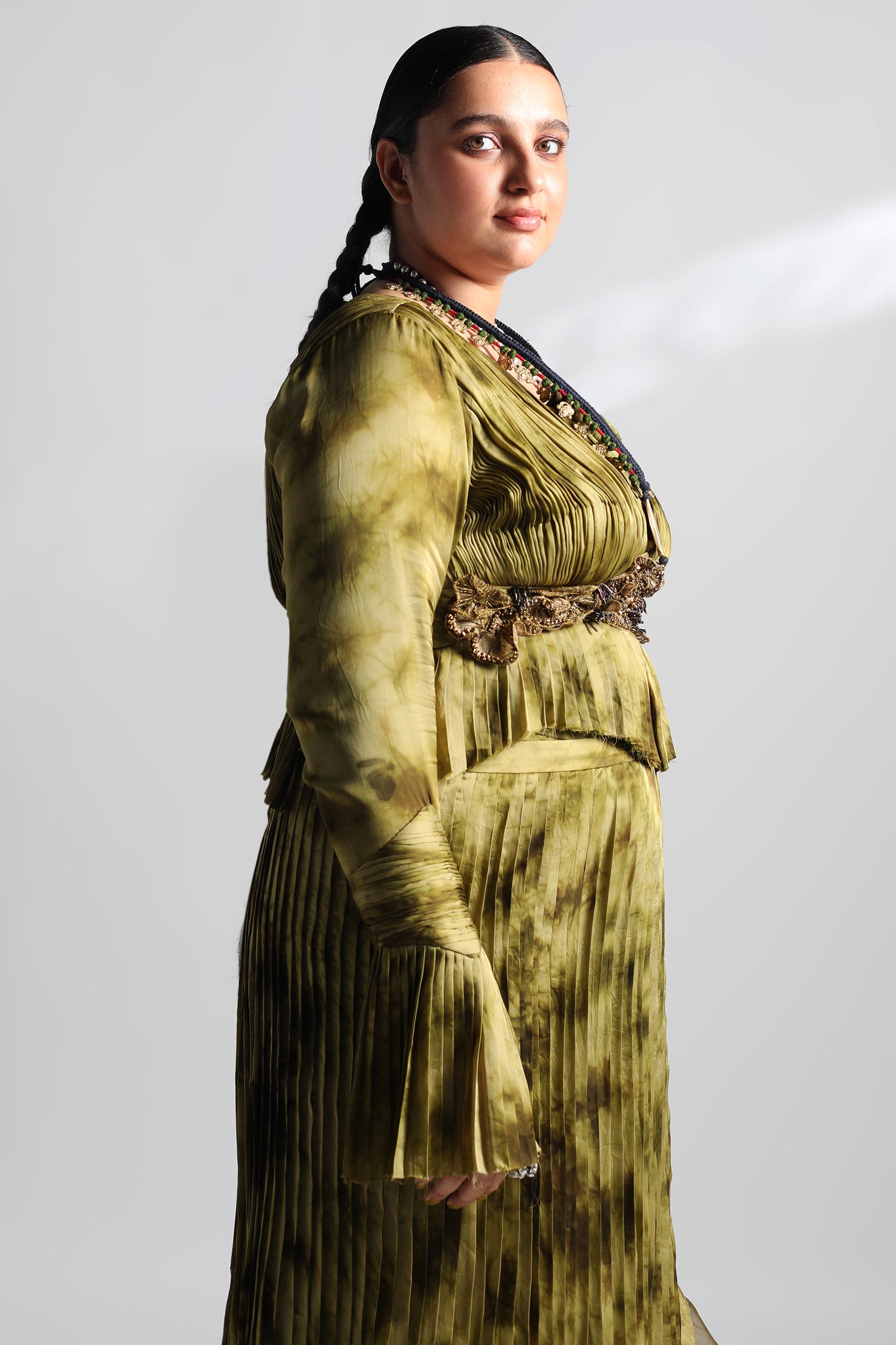 Side view of pleated skirt and ruched blouse lehenga set with dupatta