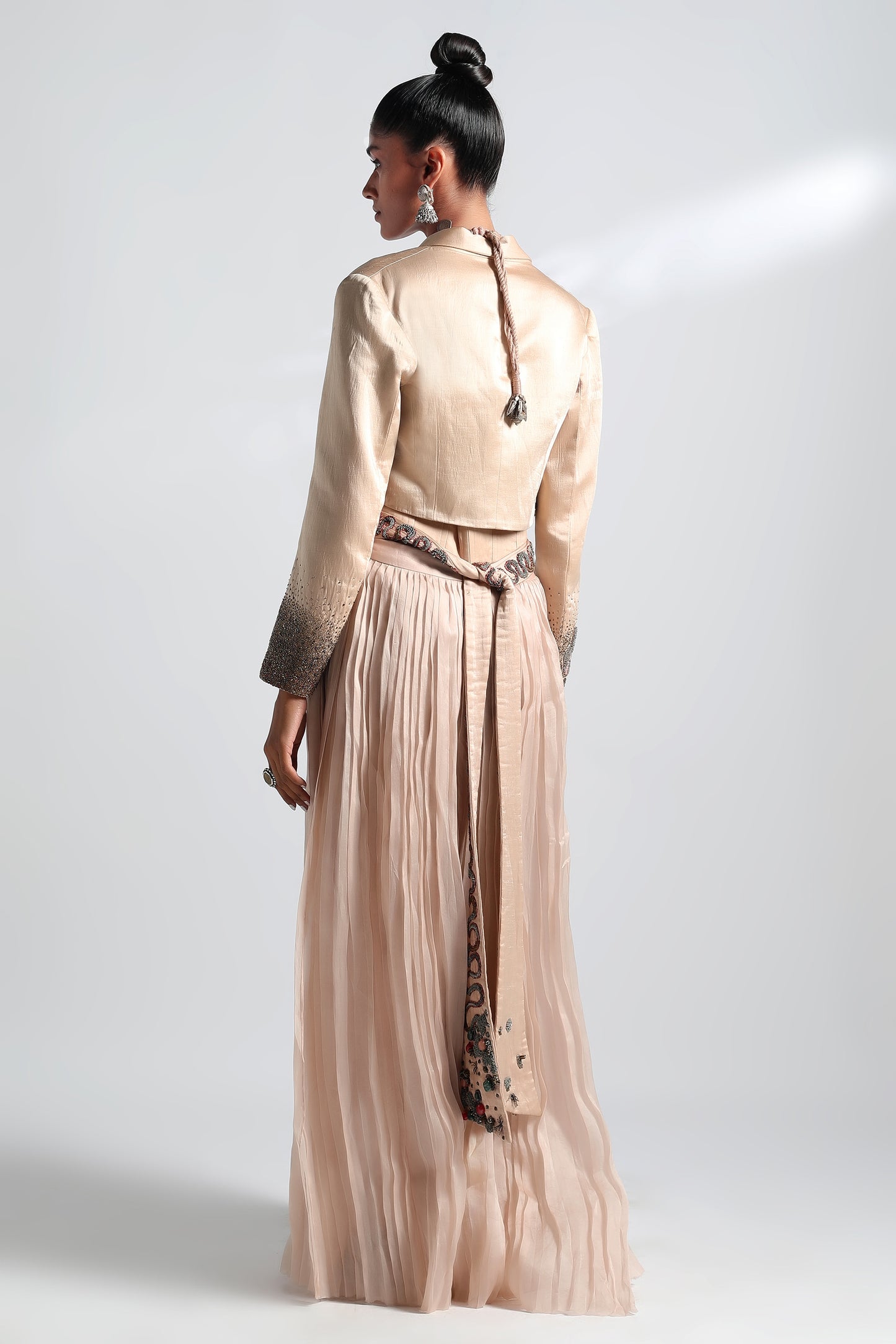 Back view of Nargis corset lehenga with embroidered jacket and pleated skirt draping