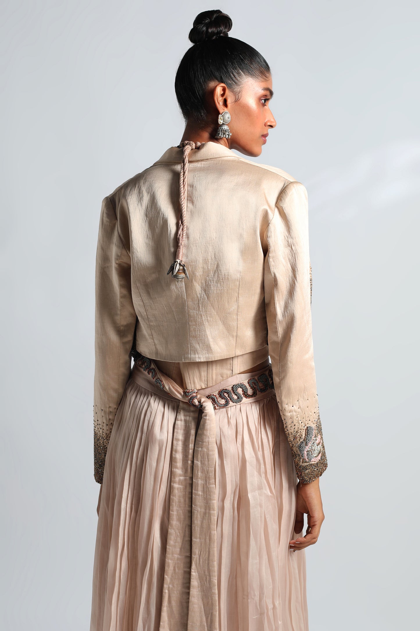 Back view of Nargis corset lehenga with pleated skirt, embroidered jacket, and belt