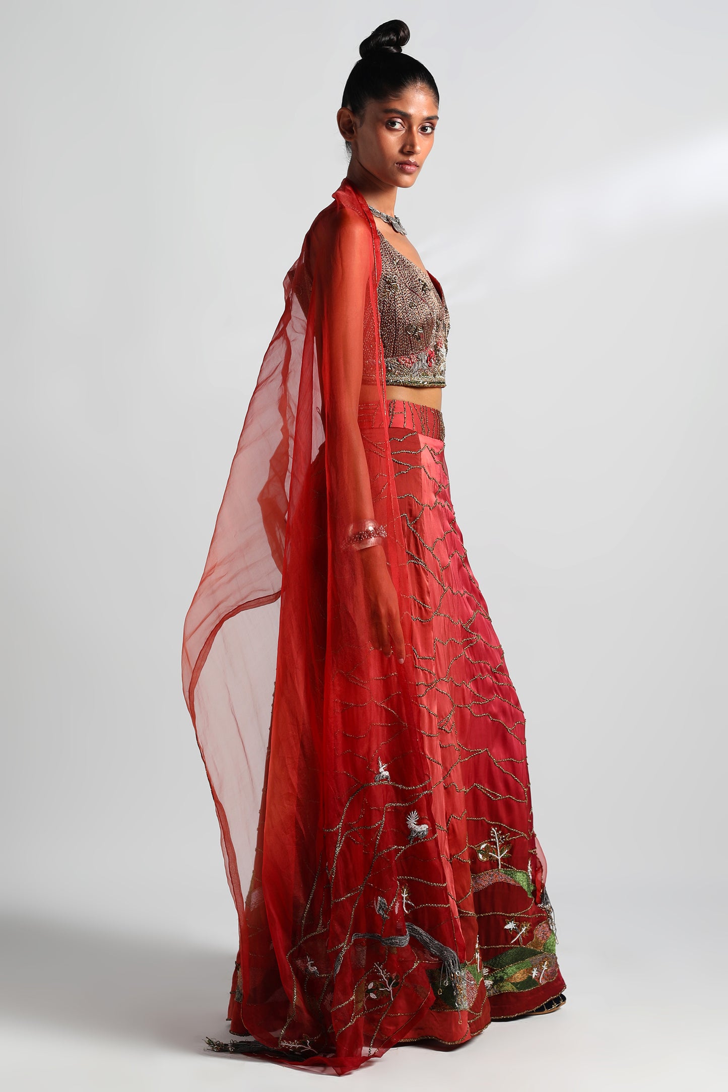 Side view of the crimson lehenga set, showcasing the corset blouse and embroidered details