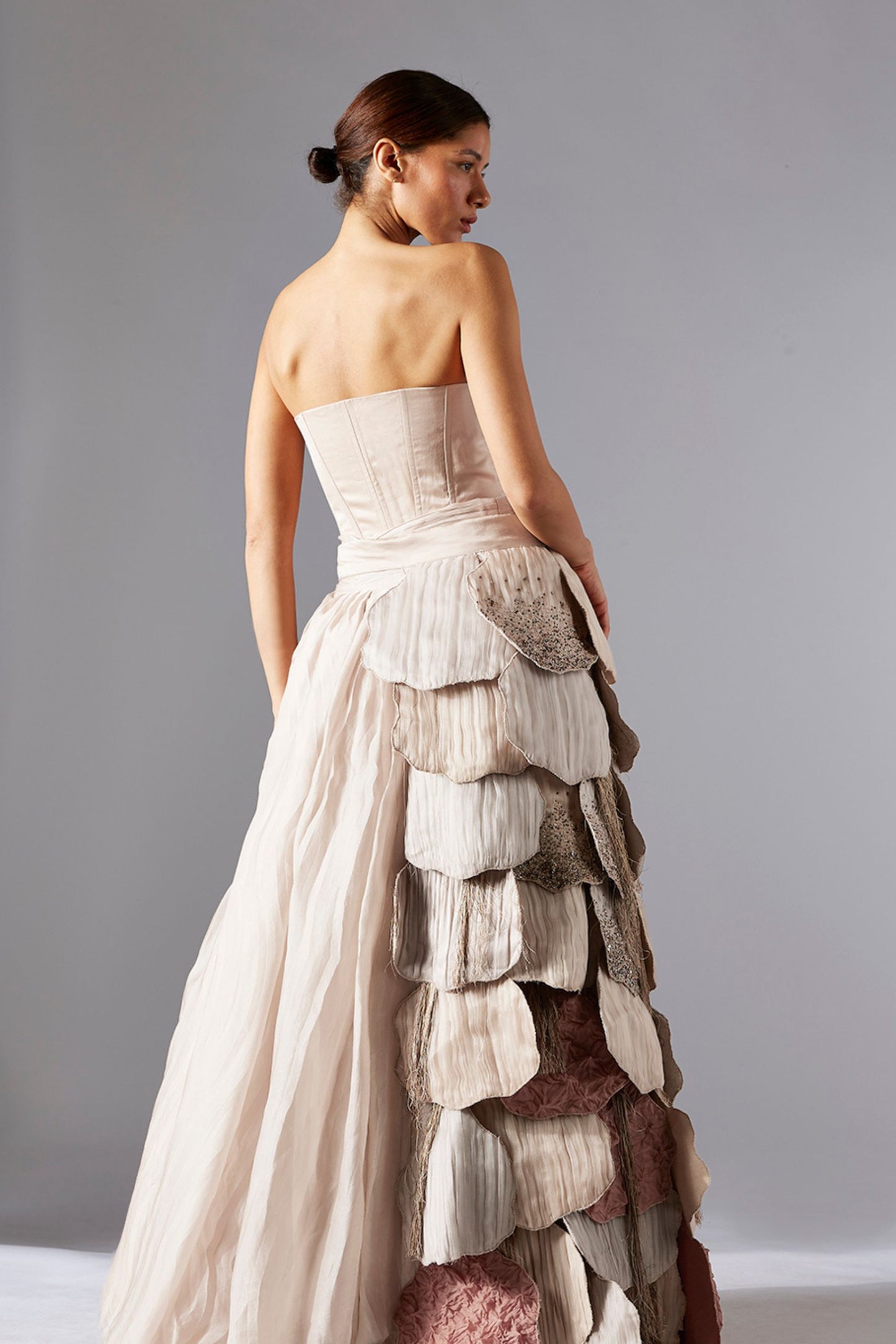 Back view showcasing the luxury designer belt and pleated skirt, emphasizing the detailed tailoring