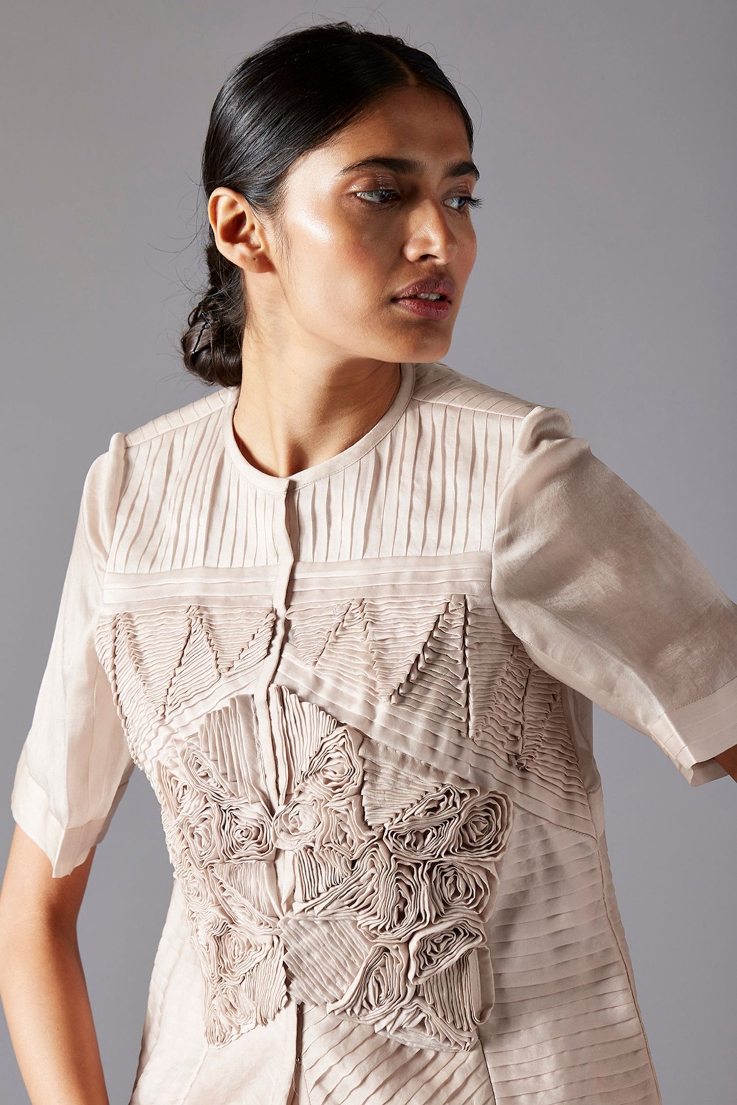 Close-up view of the geometric details on the designer jacket and the intricate pleats of the ballroom skirt