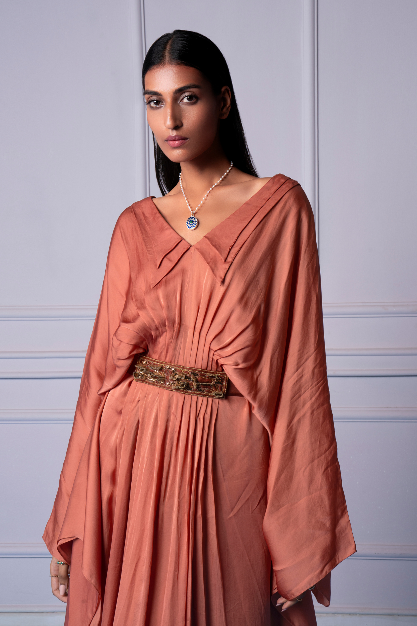 Focused view of the double collar and pleats on the kaftan dress, highlighting the luxurious fabric and detailed craftsmanship