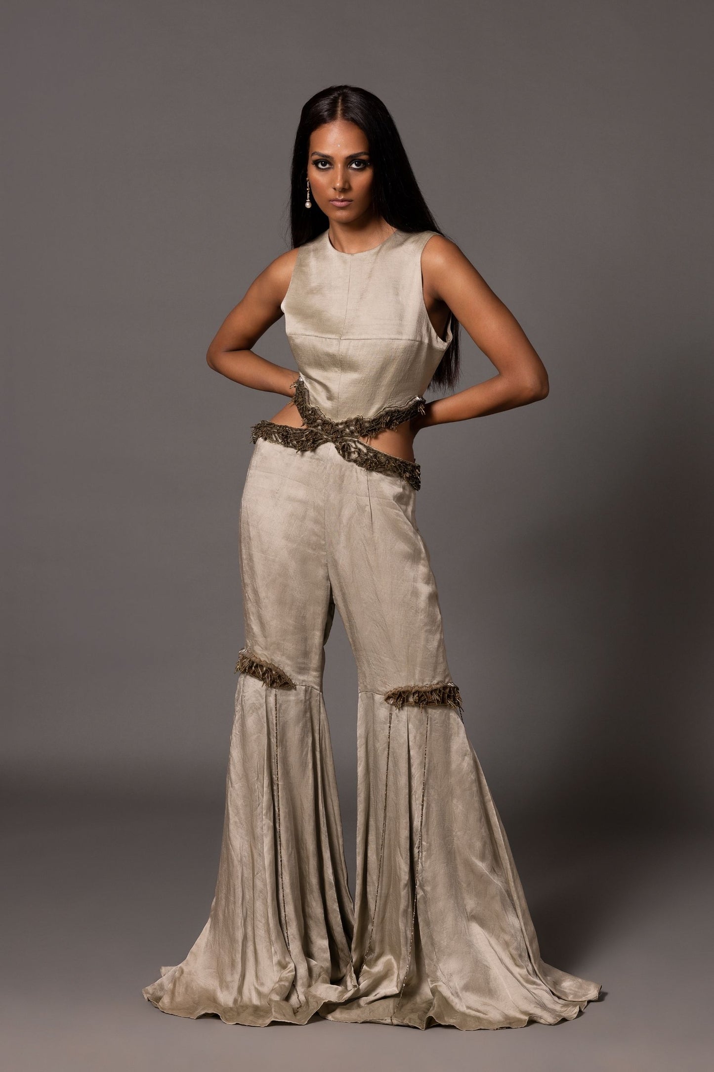 Grey Lasura sleeveless jumpsuit with waist cutouts, antique silver 3D embroidery, and flared lower with knee detailing from A Humming Way
