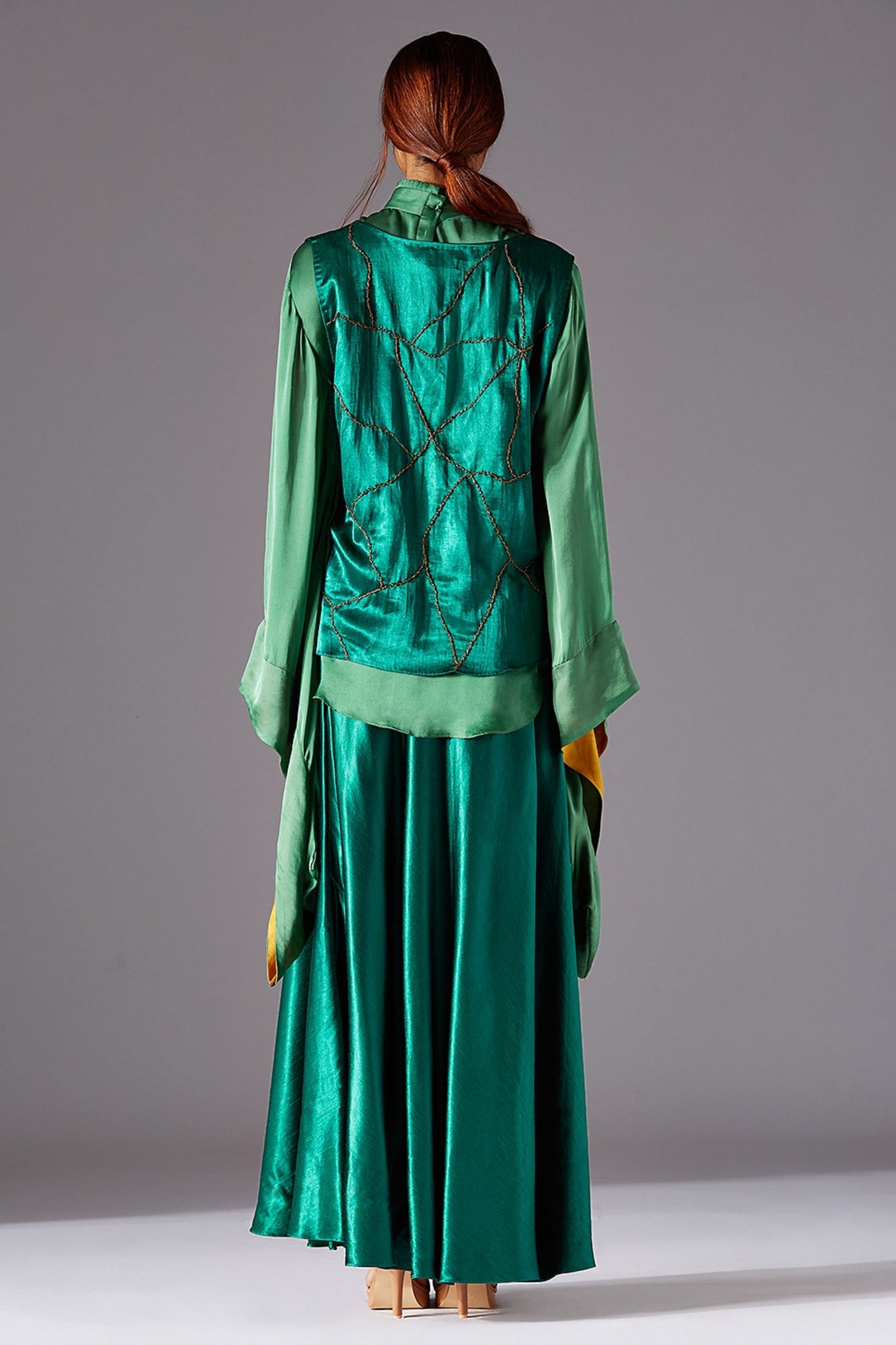 Back view of the stylish jacket for women paired with a flared long skirt, emphasizing the elegant design details
