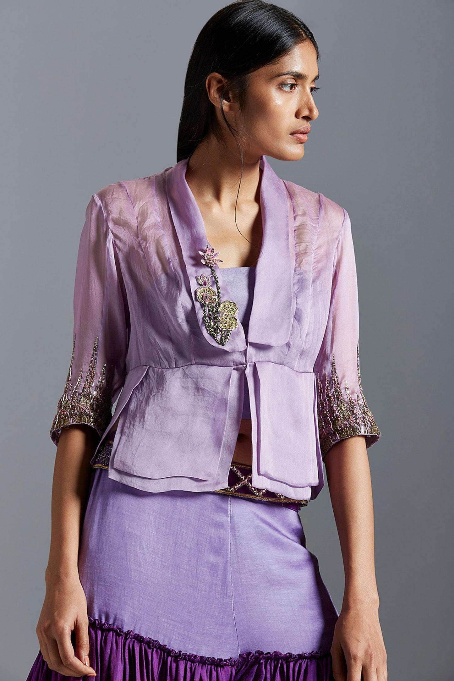 Focused view of the lotus-inspired embroidery on the blouse, showcasing the detailed work and luxurious fabric