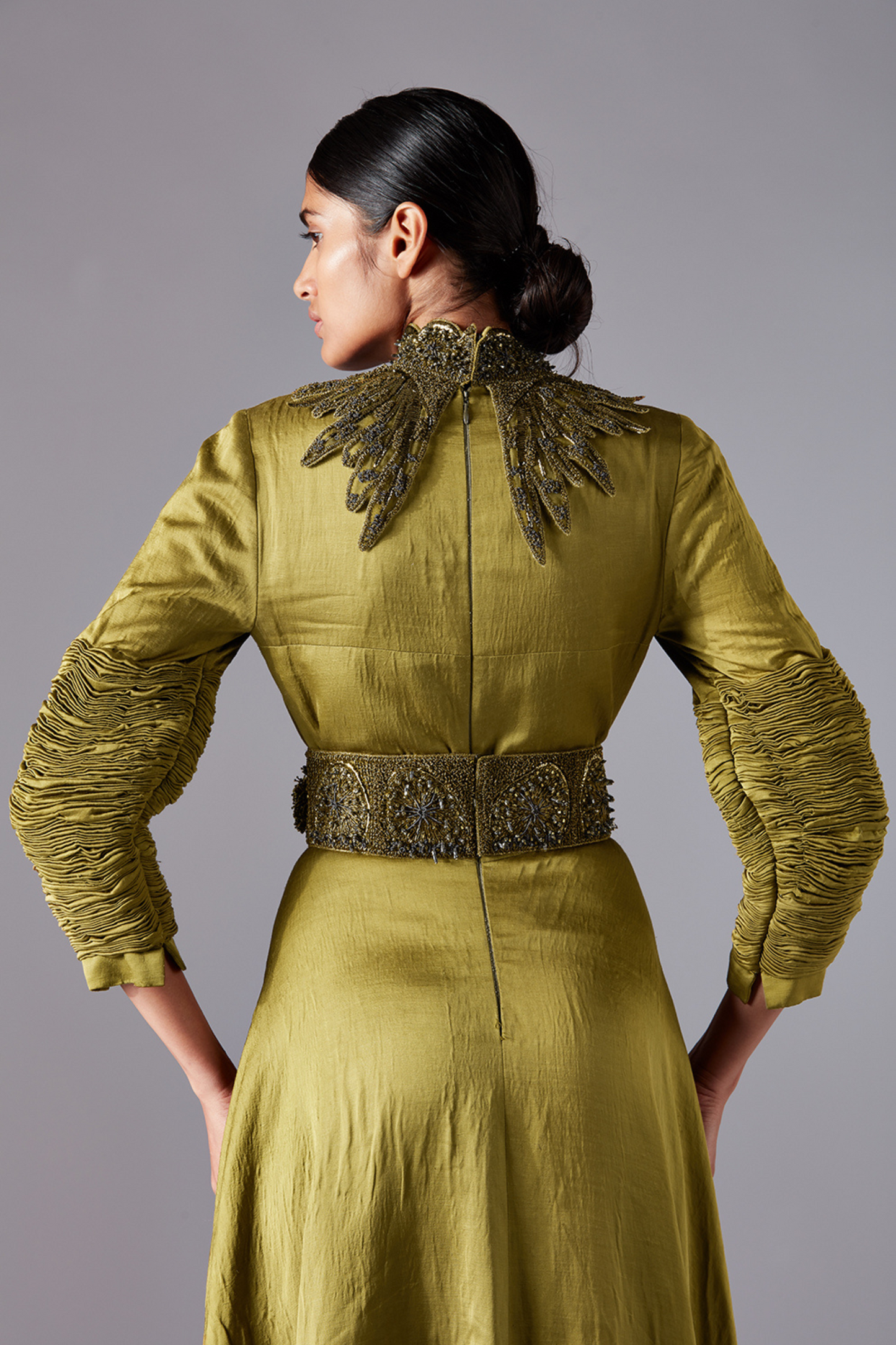 Back view of the designer gown, highlighting the flounced trail and tailored bodice for a chic look