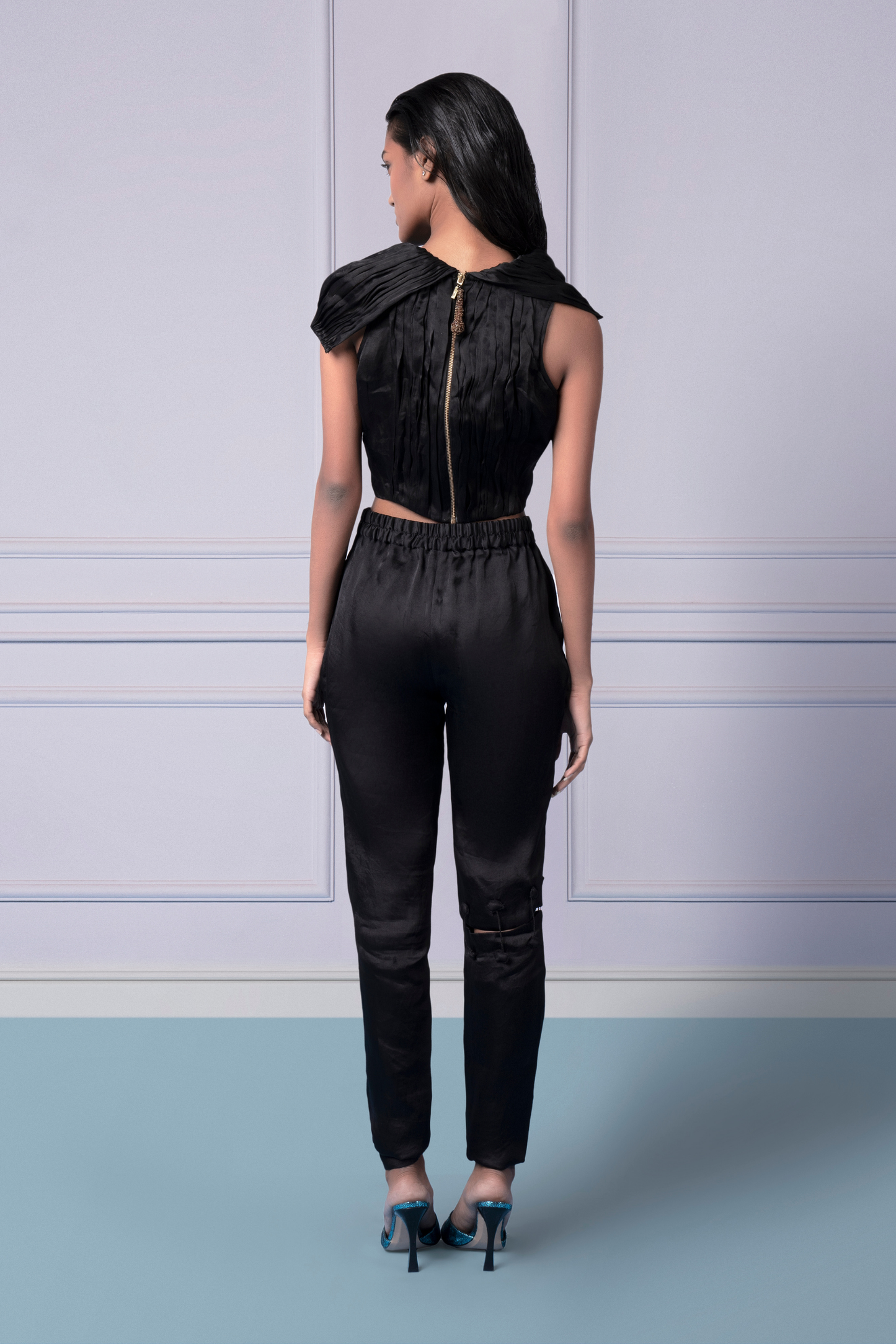 Back view of the black crop top and pants with cut-out details for a sleek and modern look