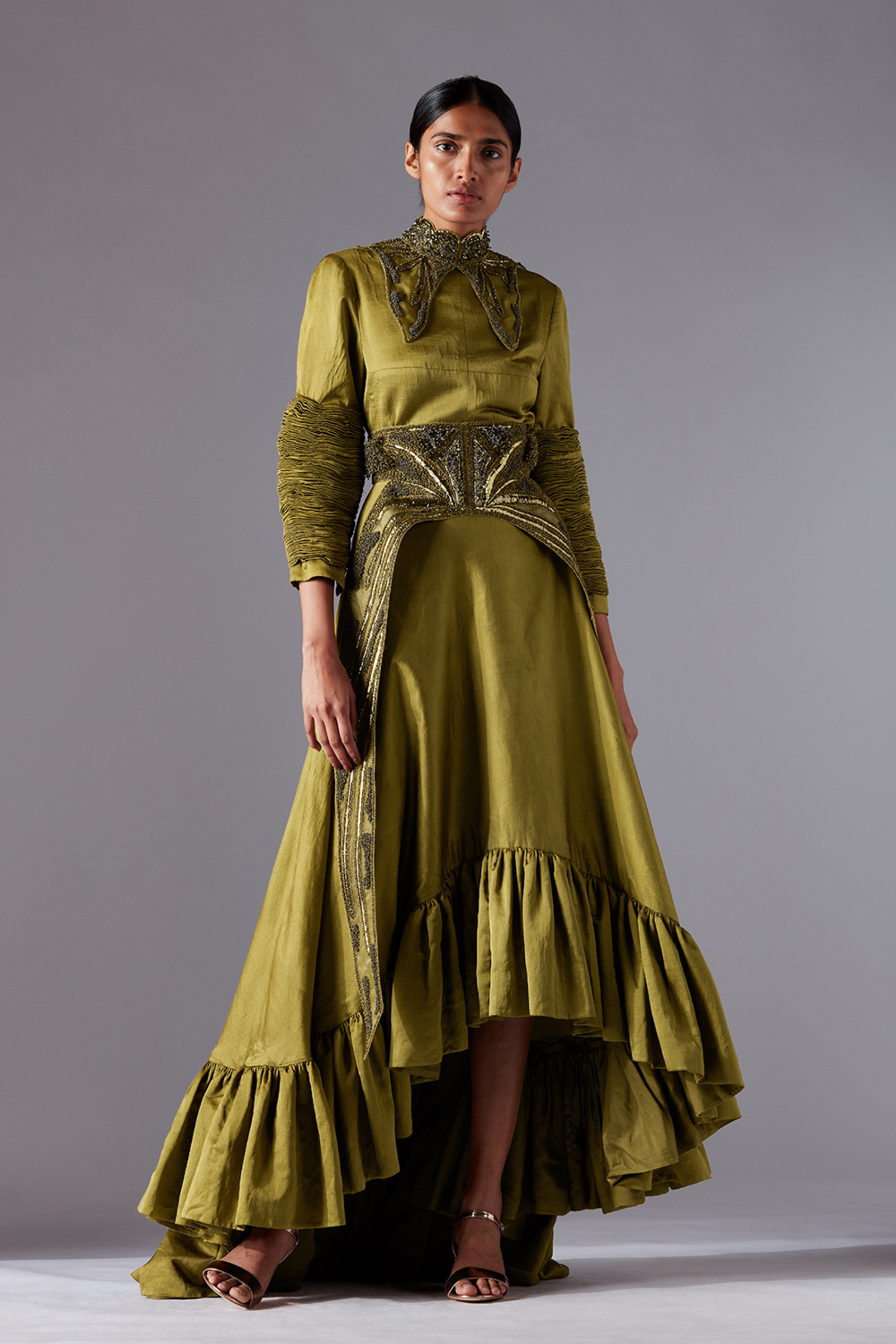Modern designer gown for women with tailored bodice, sculpted sleeves, metallic accents, and a flounced trail, perfect for elegant events