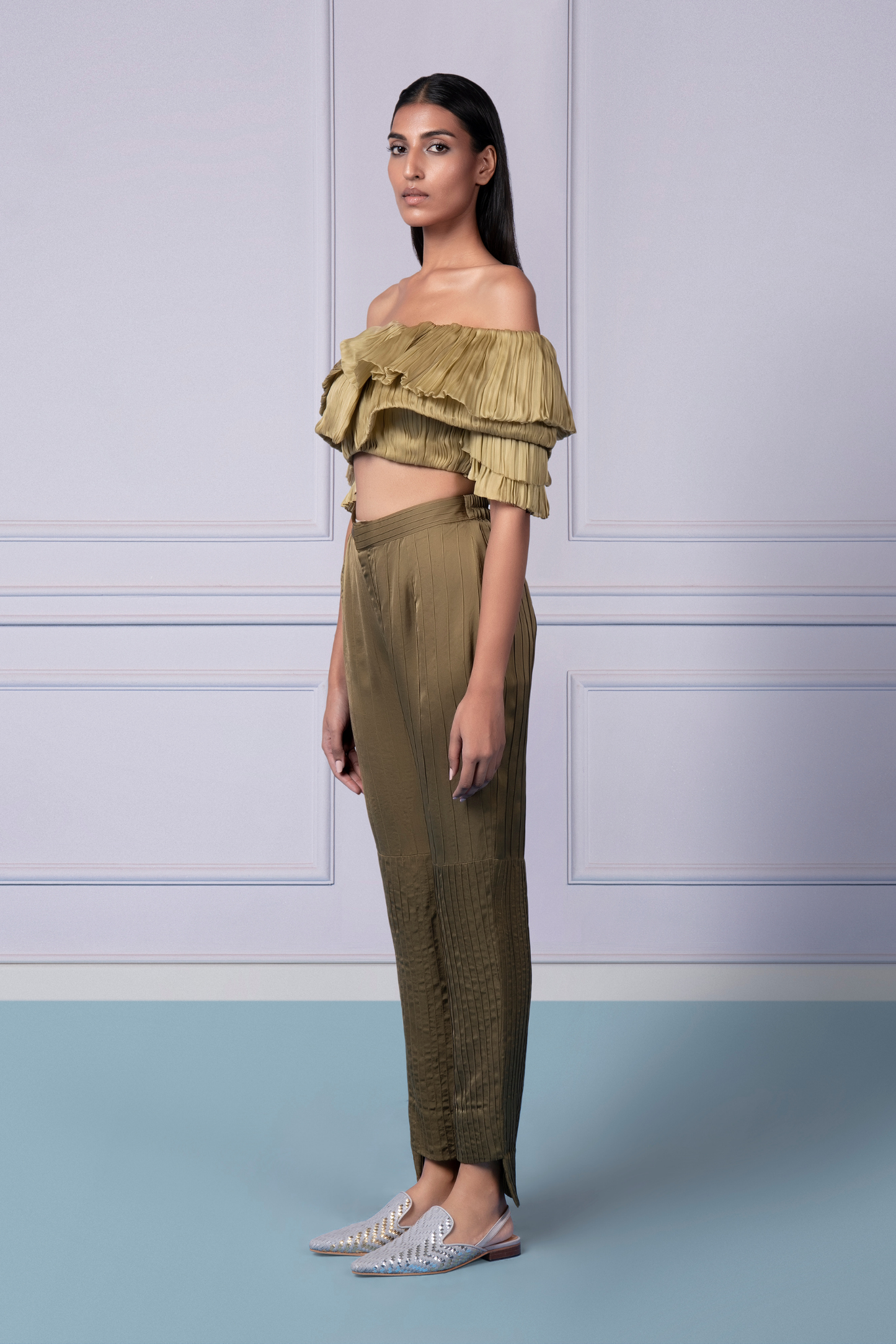 Side profile of a woman in the Gill Fungi off-shoulder crop top and pintuck pants, highlighting the stylish fit