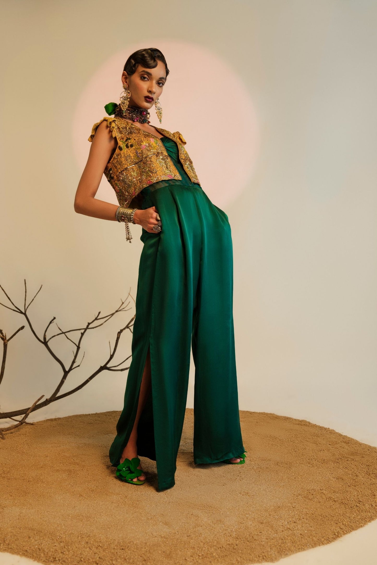 Model wearing the Namib Bottle Green Women's Jumpsuit with knotted bodice and sheer corset, paired with the Paro Cropped Embroidered Jacket featuring exquisite Zardosi handwork