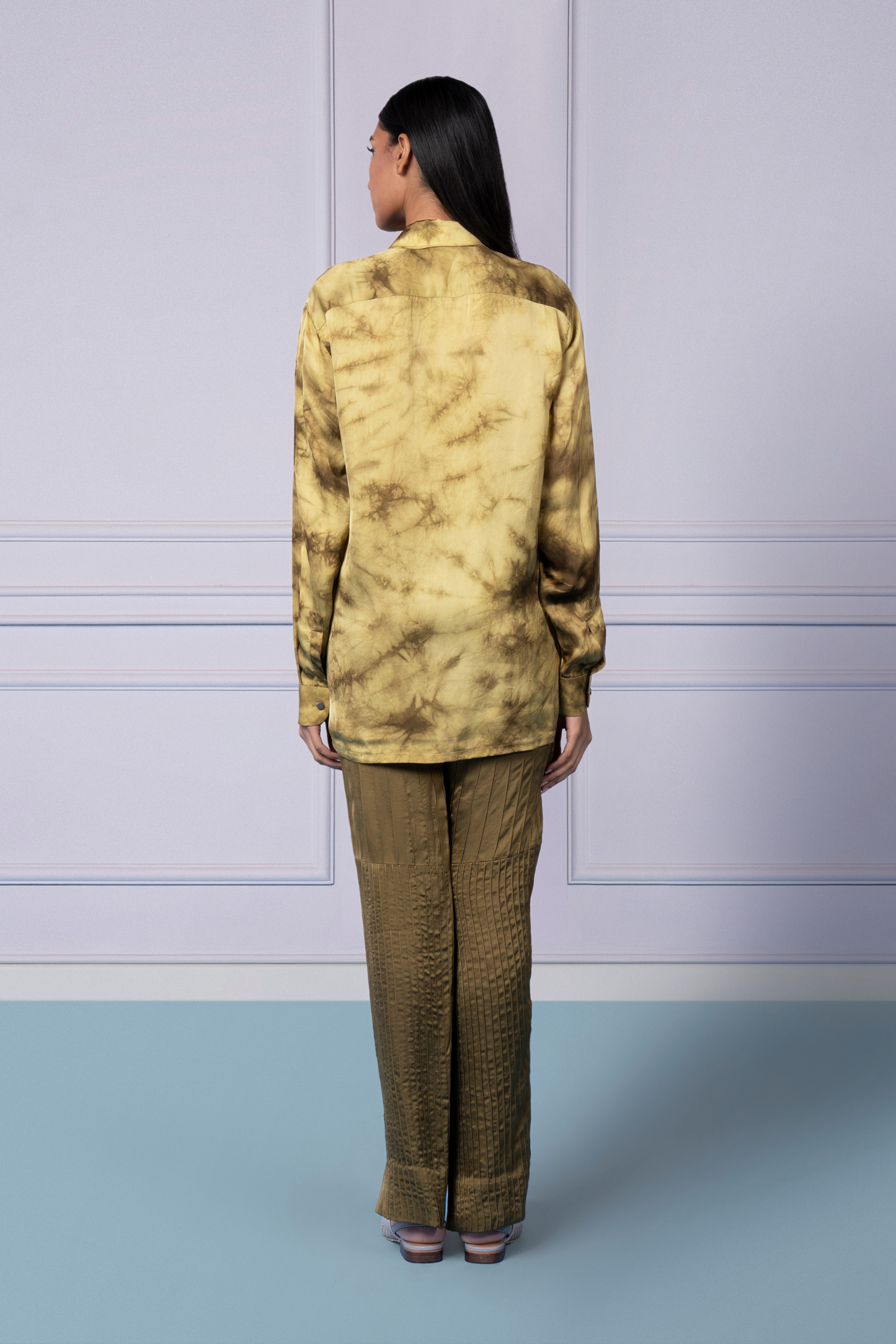 Back view showcasing the tie-dye shirt and the elegant pintuck pants for a fashionable look