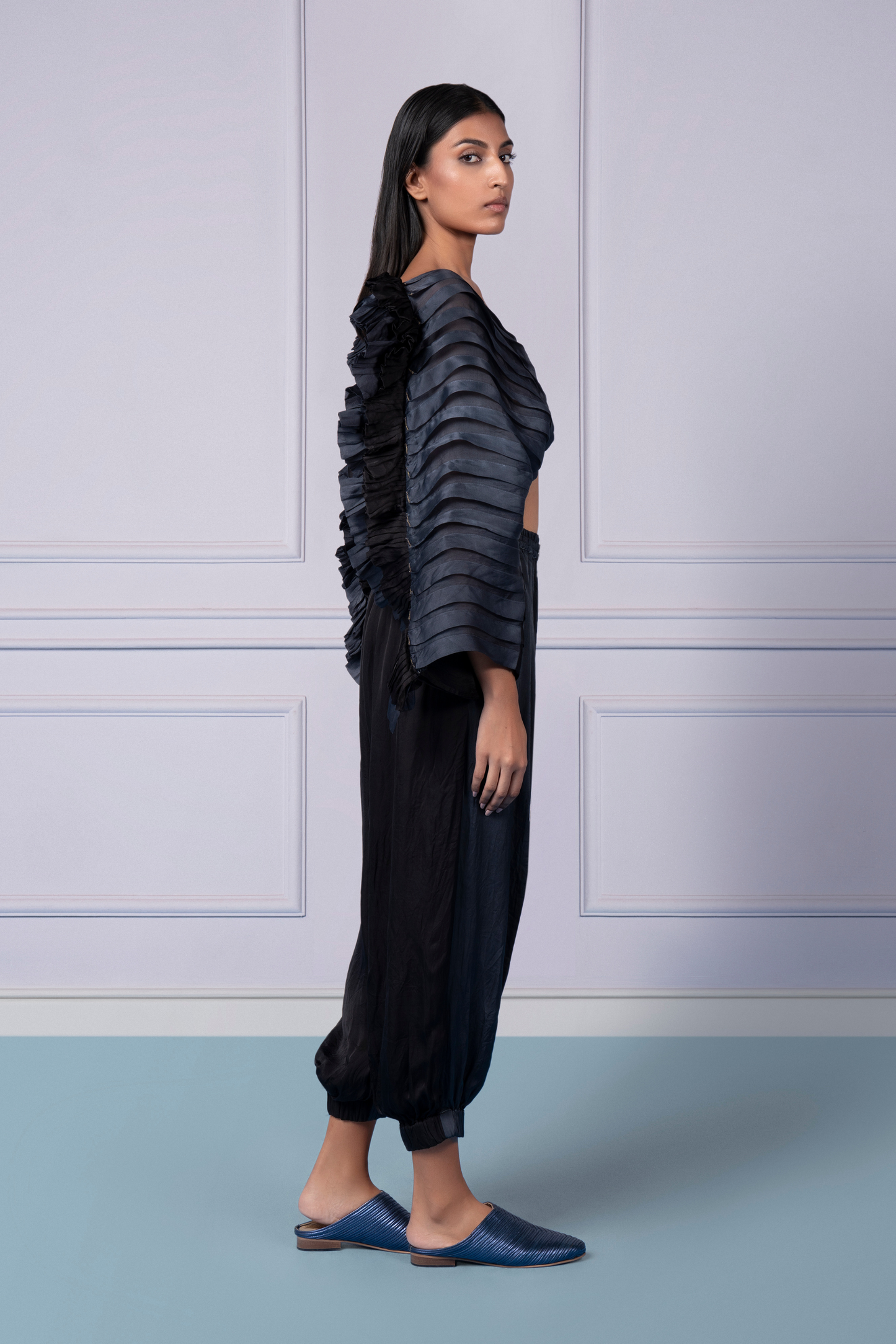 Side profile of a woman in the Mushroom pleated top and joggers, highlighting the stylish fit and slit details