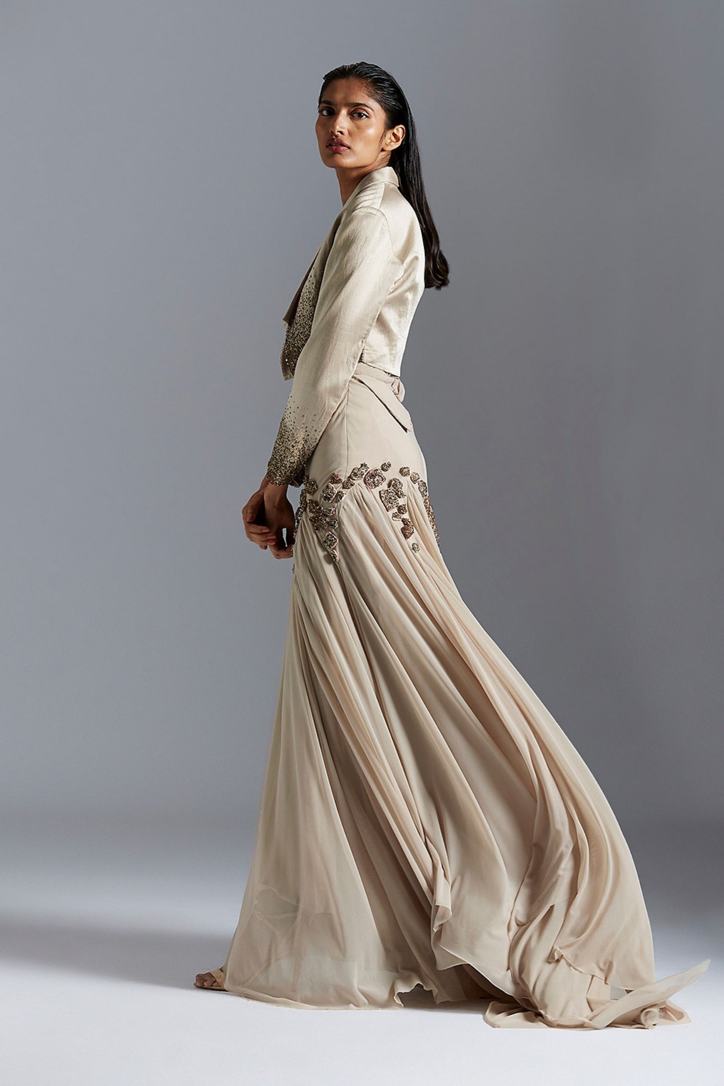 Side profile of the couture gown with embroidered tuxedo jacket, emphasizing the chic silhouette and detailed embellishments