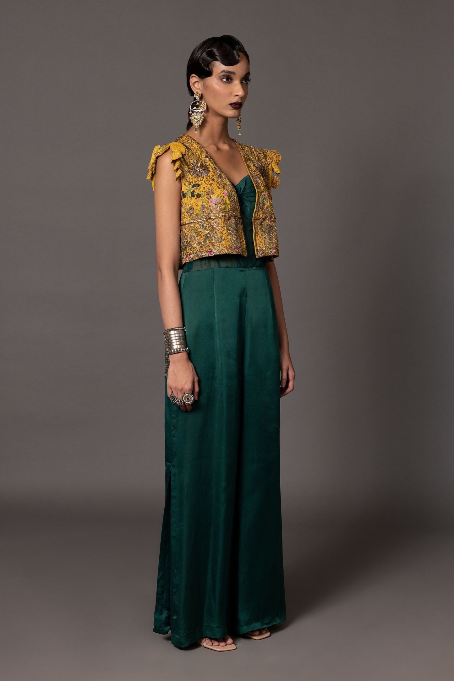 Full view of the knotted bodice and sheer corset of the Namib Bottle Green Women's Jumpsuit paired with the embroidered jacket
