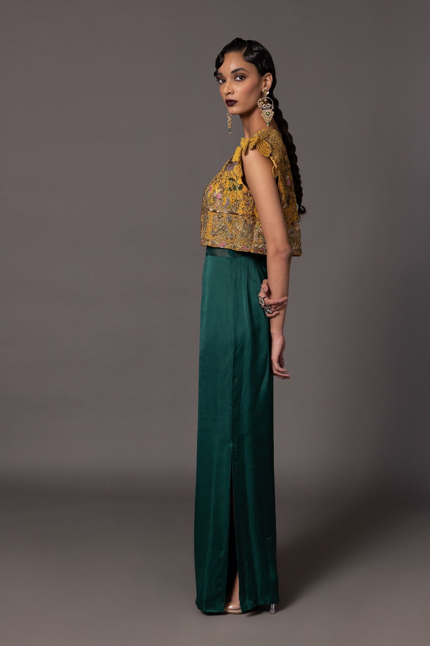 Side view of the Namib Bottle Green Women's Jumpsuit with sheer corset and embroidered jacket, showing the silhouette and design