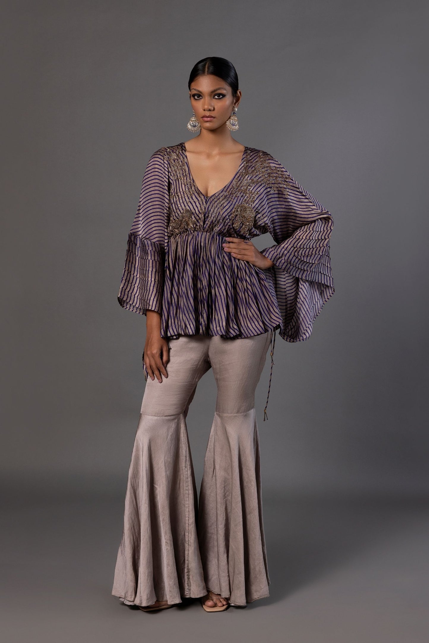 Shikhar Baugh Women's Peplum Top with metallic embroidery featuring animal, tree, and floral motifs, paired with elegant grey gharara pants