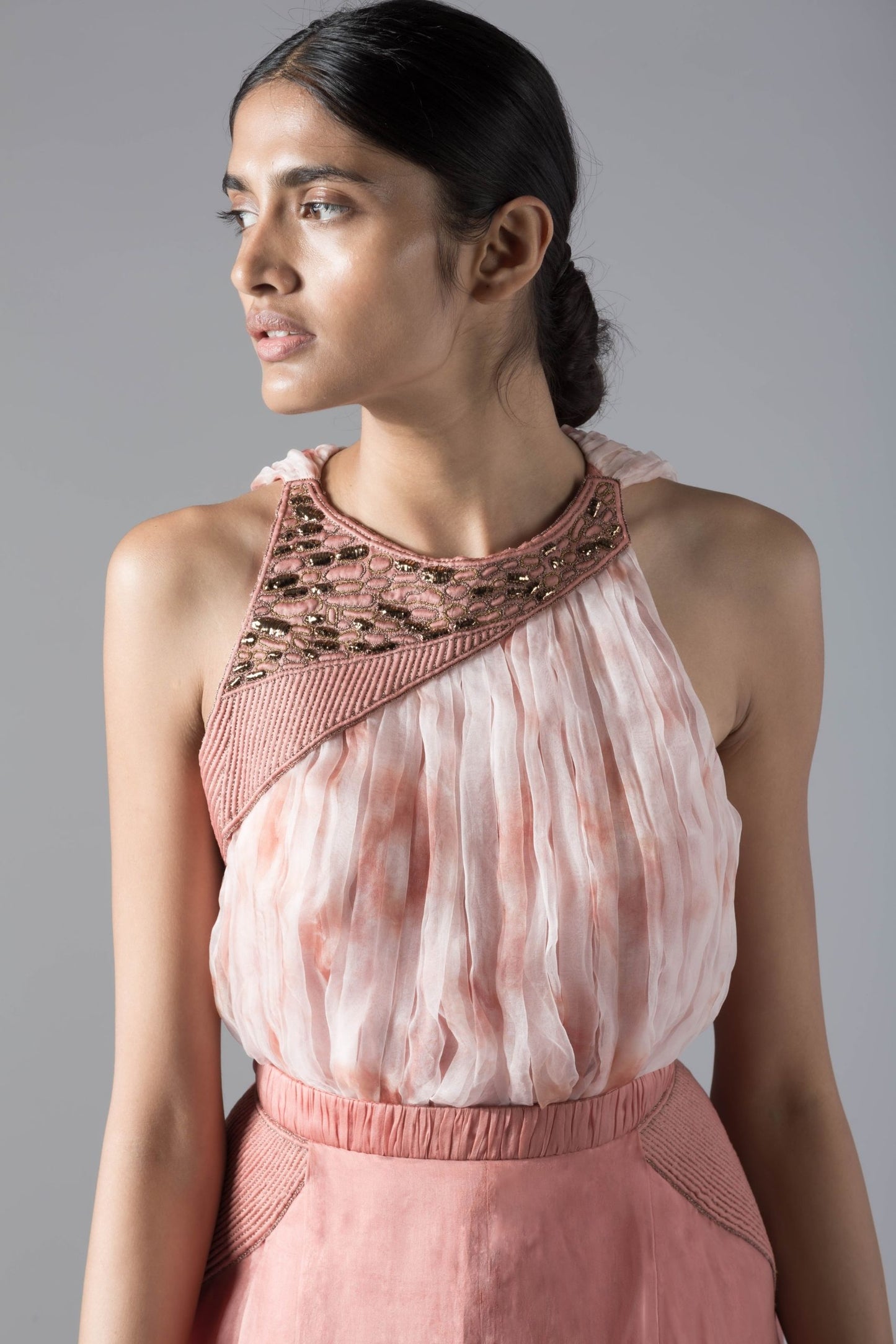 Close-up of the batik-dyed rouched crop top and pleated pant skirt with rope inlayed details, highlighting intricate design features