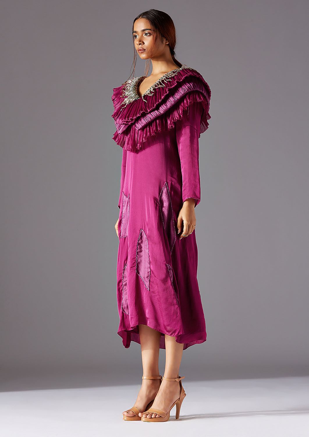 Side profile of the designer dress, emphasizing its layered ruching and sleek fit
