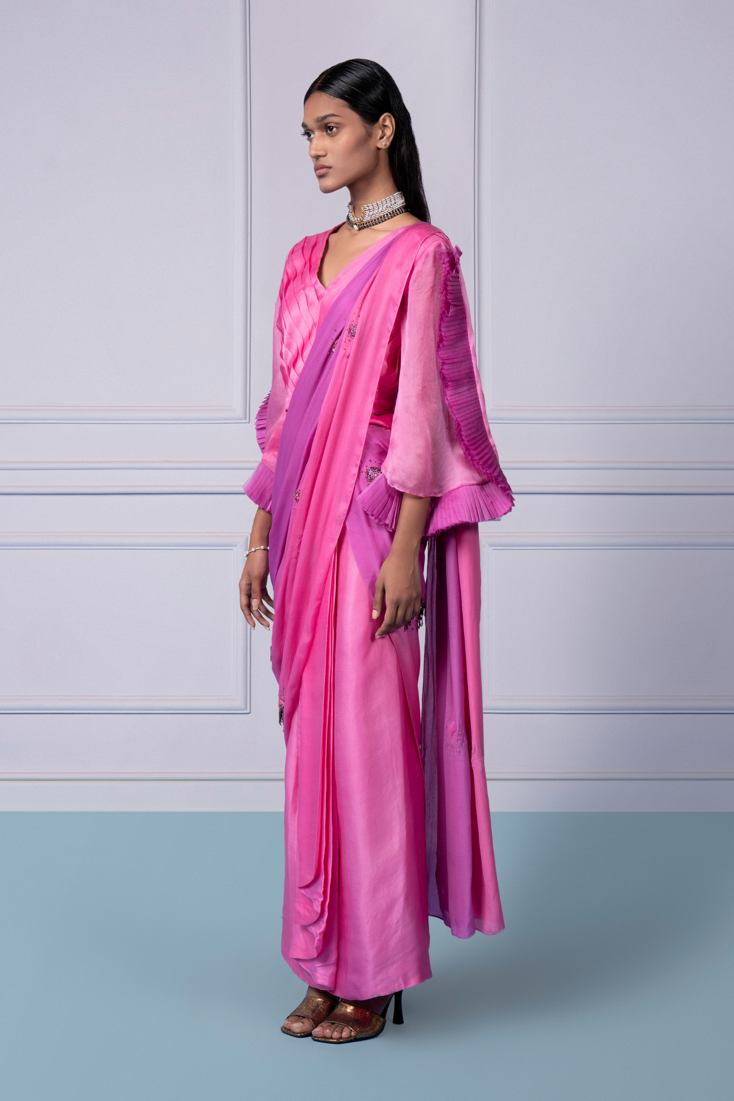 Side view of the pink lehenga saree set for women, emphasizing the pleated blouse and graceful silhouette
