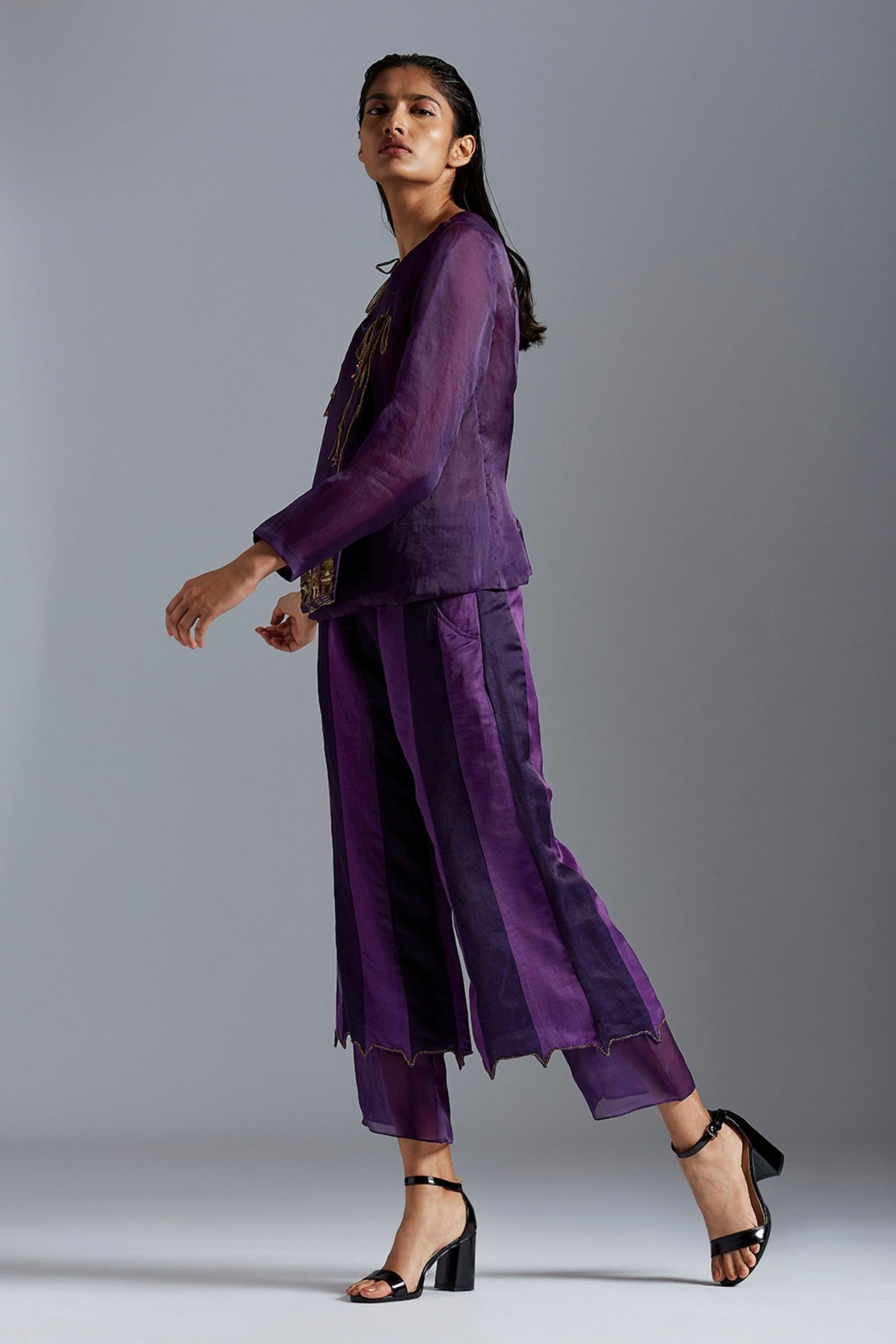 Model wearing the pant and top set, featuring satin organza Angarakha coat with metallic embroidery and color-block layered pants, exuding modern elegance