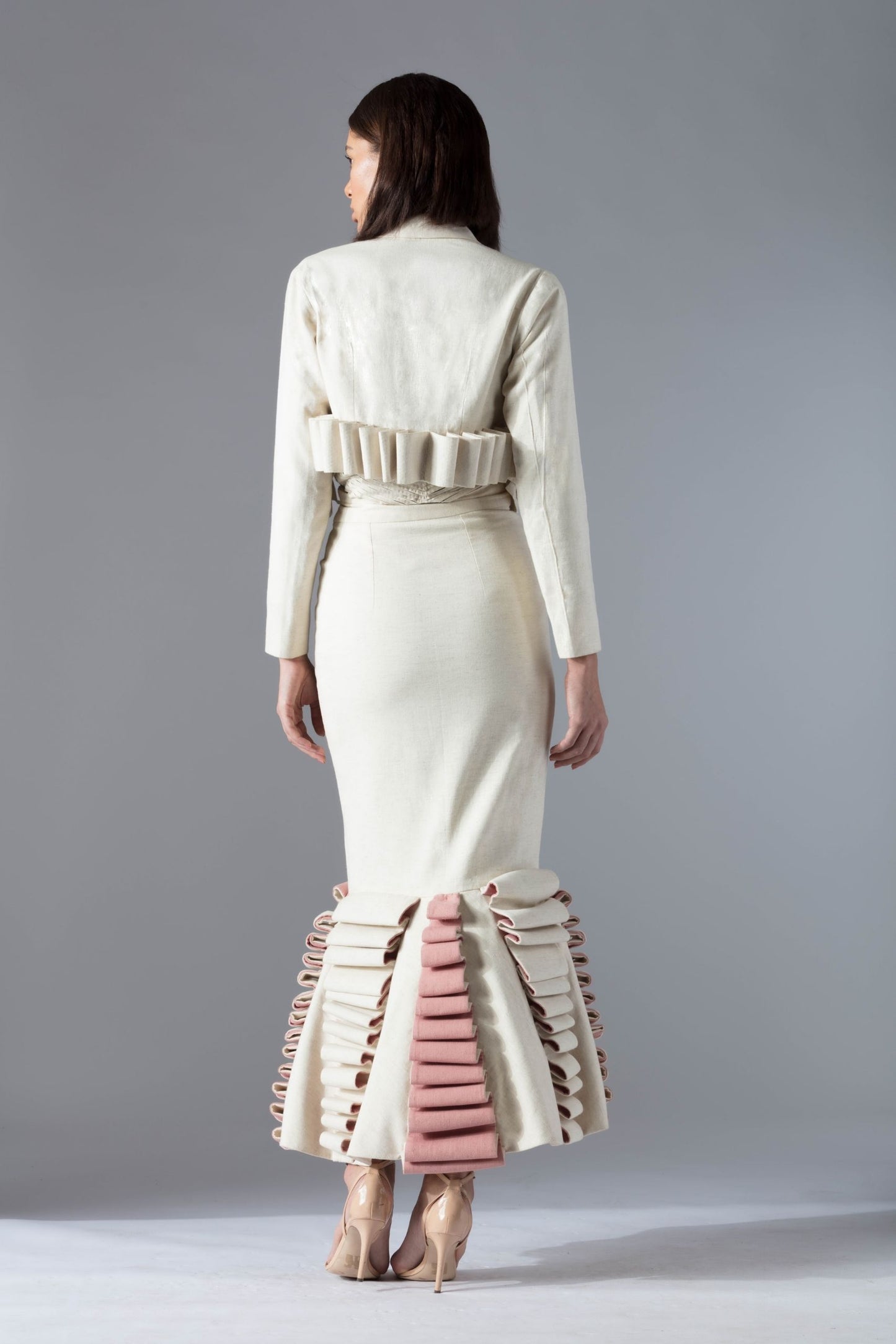 Back view of the white tuxedo jacket and corset skirt set highlighting the couture fit and tailoring