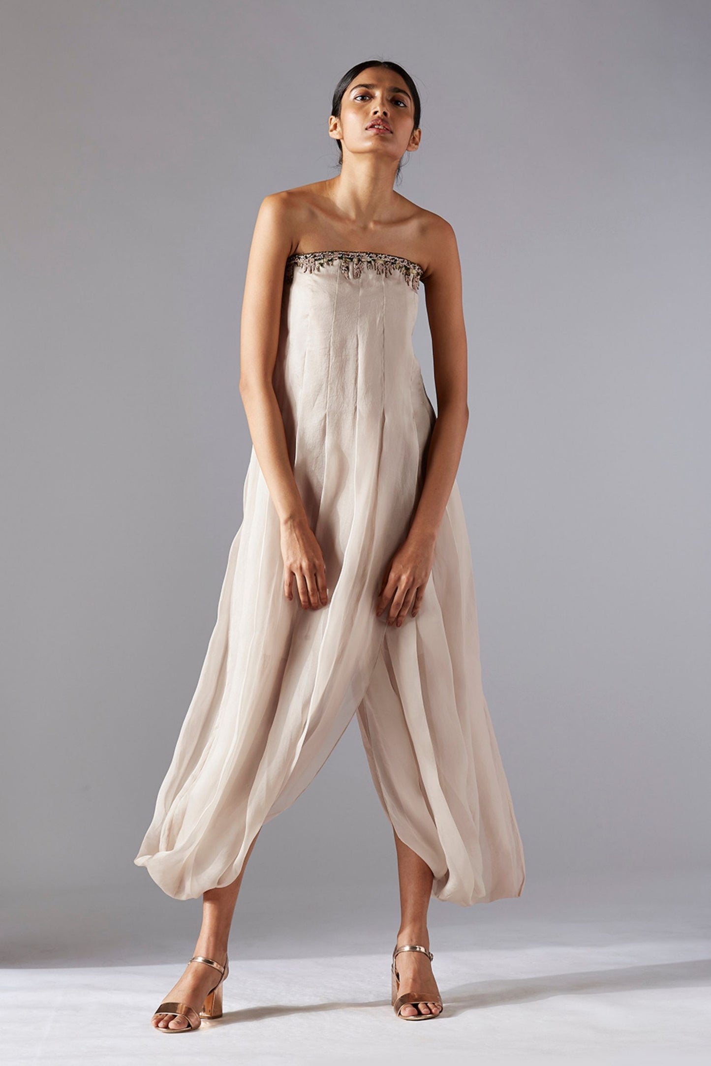 Woman confidently styling the pleated tube jumpsuit, perfect for a modern and sophisticated look
