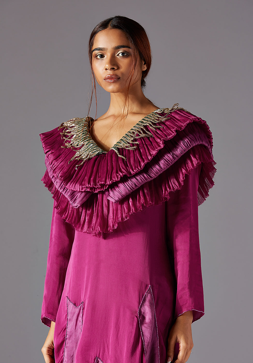 Detailed view of the ruching layers and metallic elements, showcasing the dress’s craftsmanship and unique features