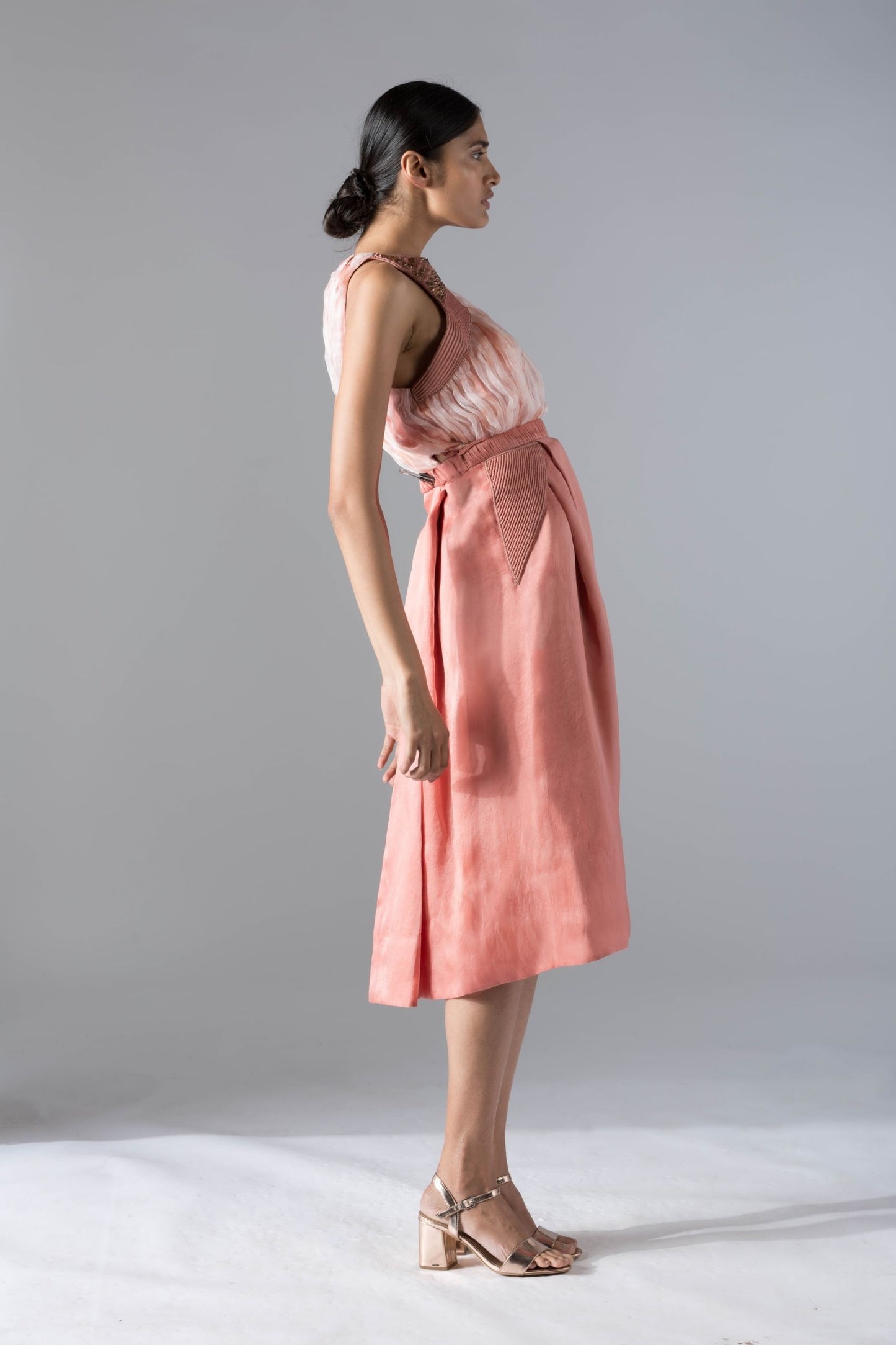 Side view of the chic top skirt set for women, focusing on the silhouette and pleated details of the pant skirt