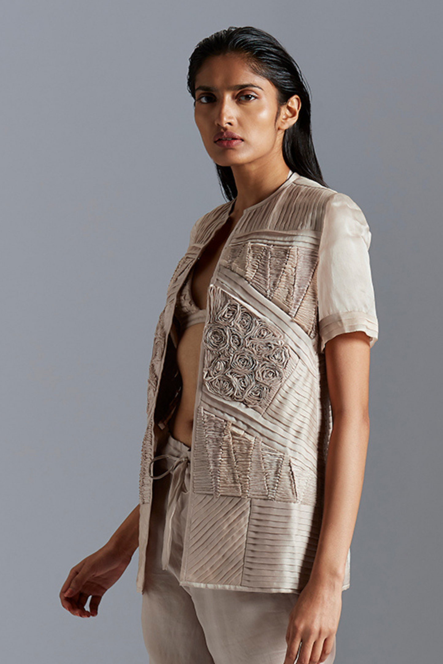 Stylish fabric manipulation jacket, highlighting the modern design and intricate geometric details for a chic look