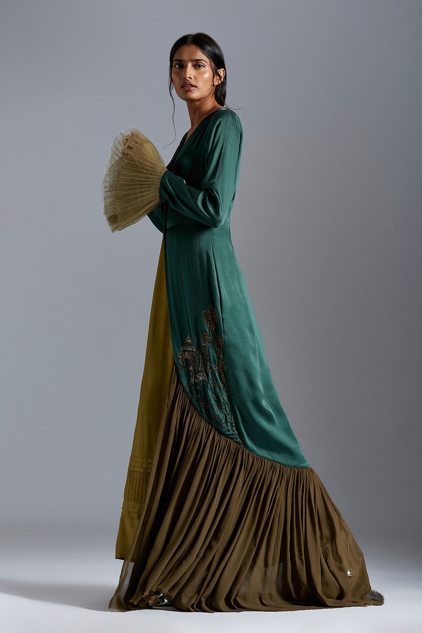 Side view of the designer gown for women, emphasizing the flowing design and architectural-inspired embroidery