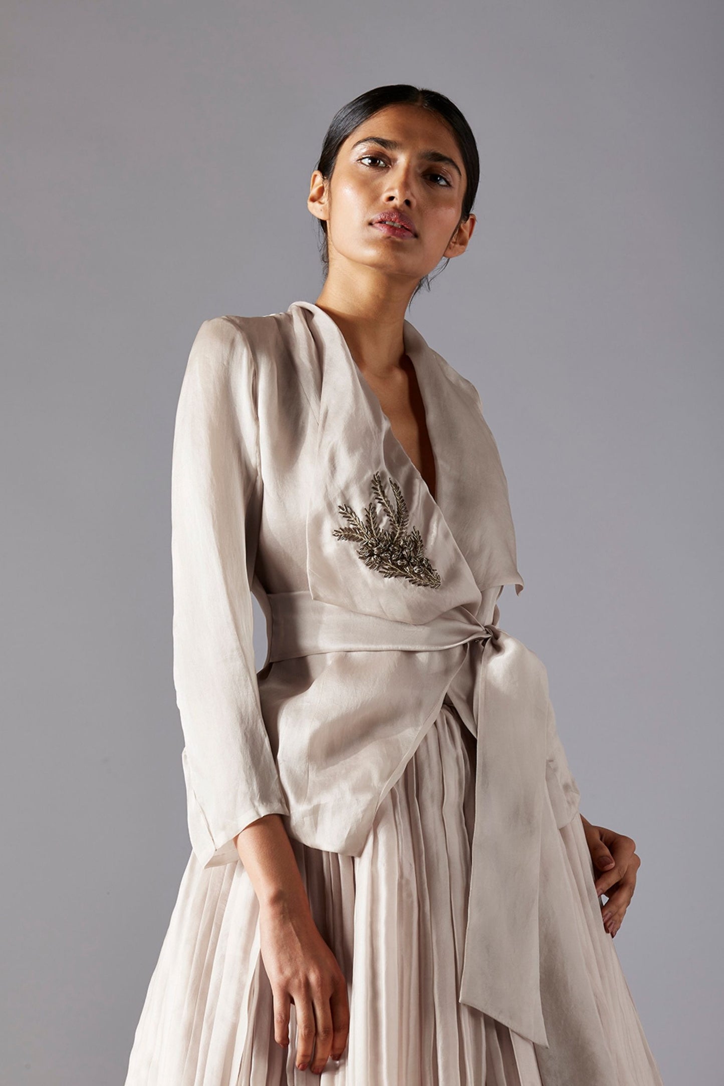 Close-up view of the intricate 3D metallic work on the designer organza jacket and the pleated texture of the ballroom skirt
