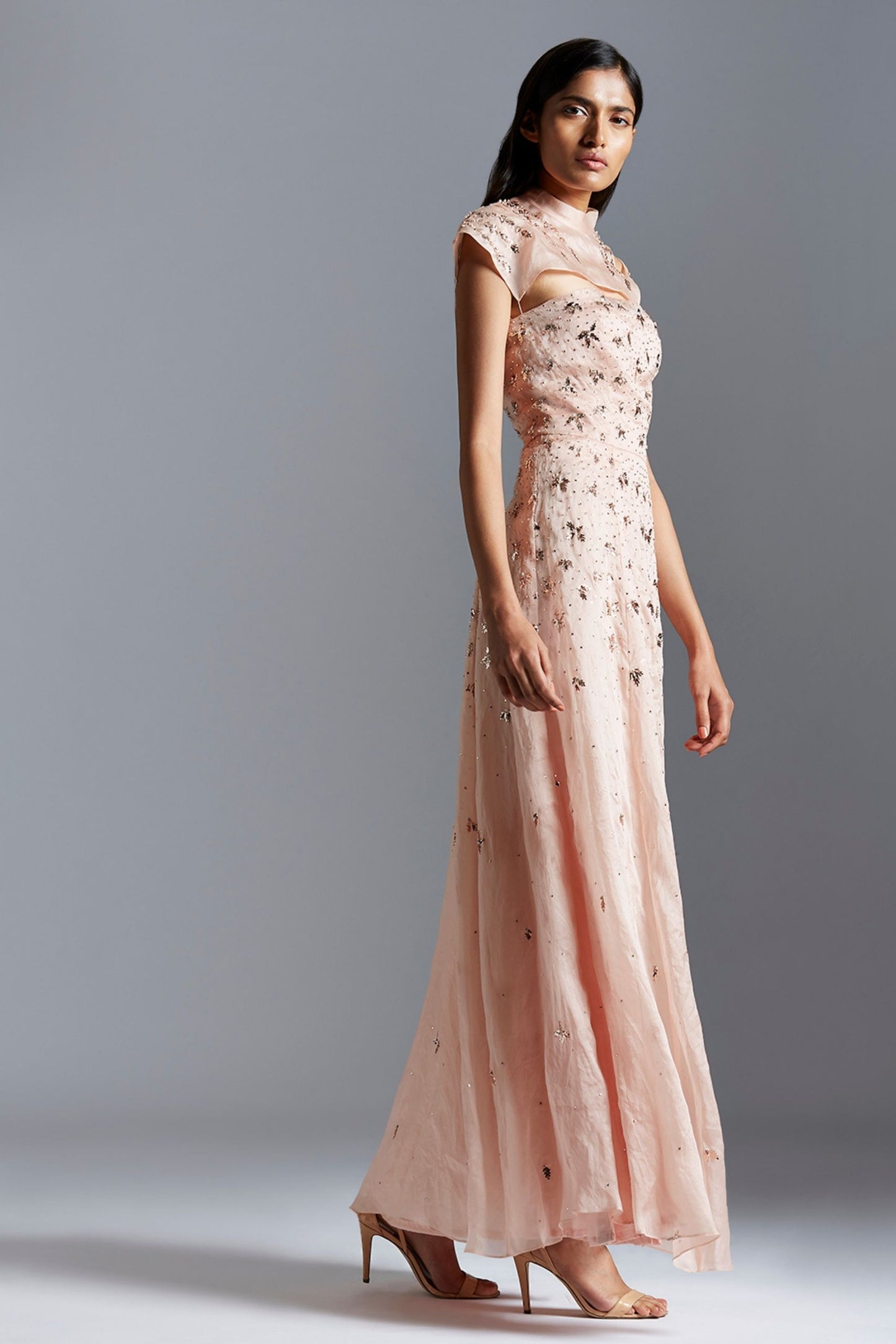 Side profile of the designer gown, showing the smooth drape of the satin organza and the detailed mukaish work