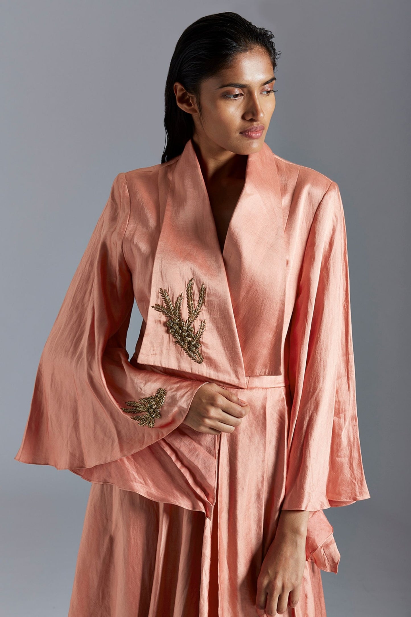Close-up of the golden metallic detail on the draped dress, emphasizing the intricate craftsmanship
