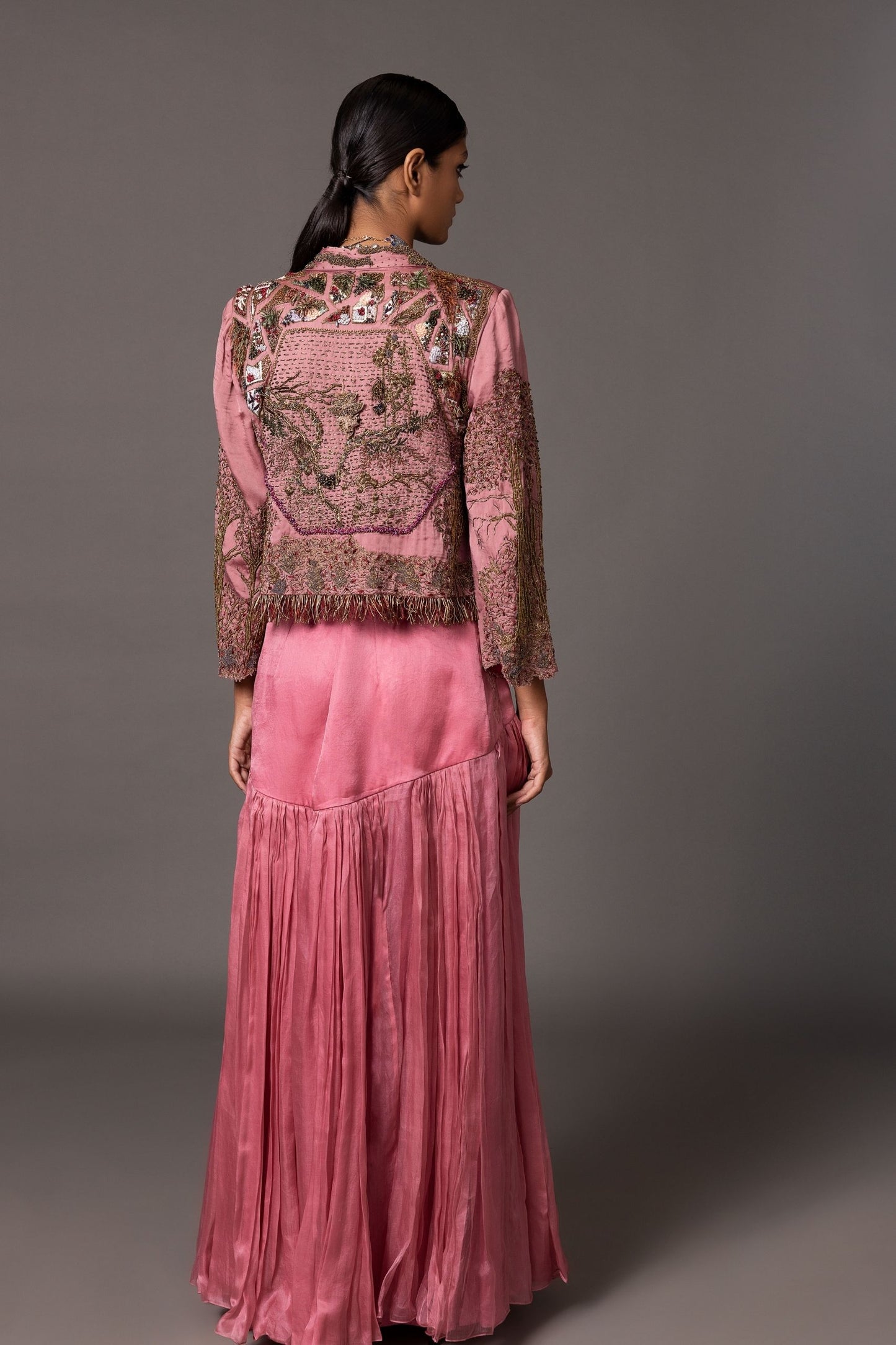 Back view of the Kaner Pink Corset Top & Skirt with Earth Jacket, showcasing the detailed embroidery on the jacket