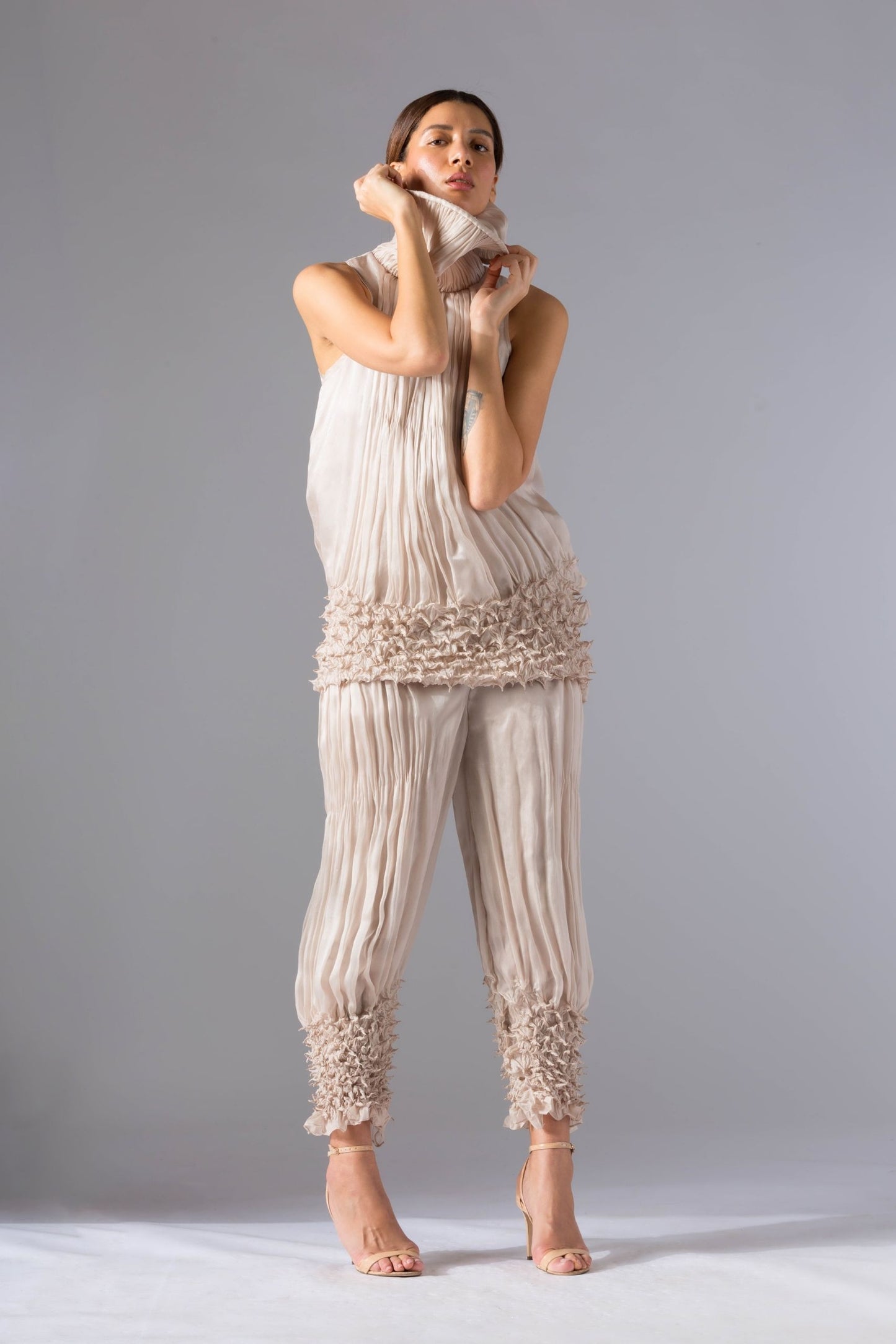 Chic women's top pant set featuring a rouched drop-waist top and narrow sculpted pants, offering modern elegance and stylish design