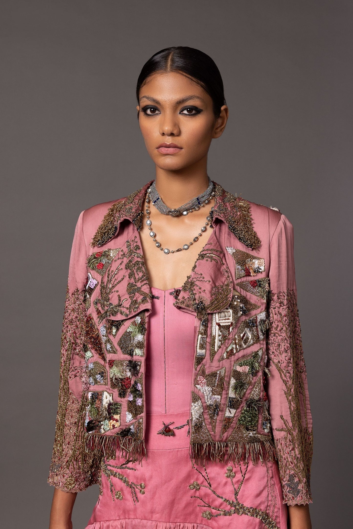 Close-up of the heavy multimedia embroidery on the Earth Jacket paired with the Kaner Pink Corset Top & Skirt