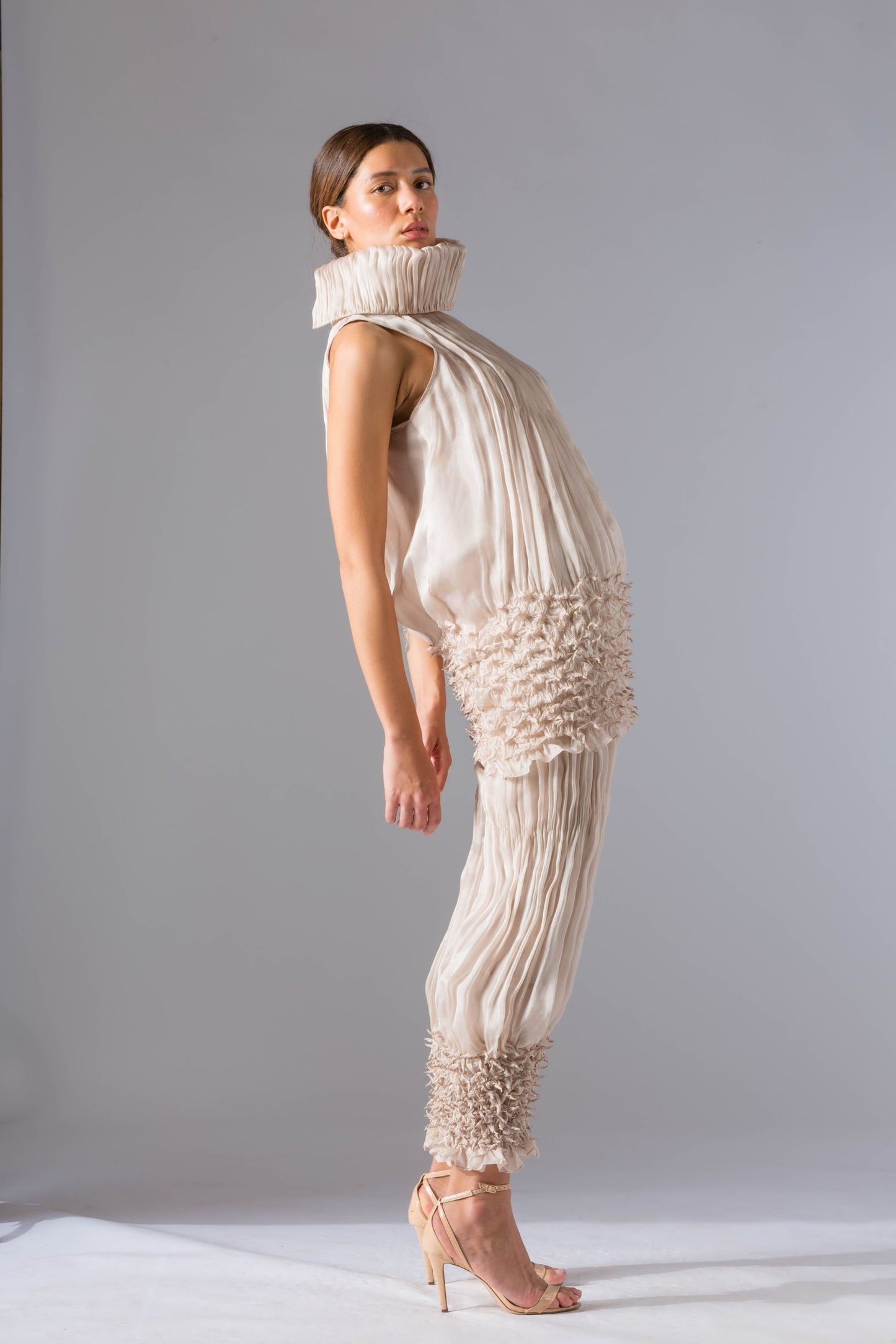Side view of the stylish women's top pant set, highlighting the sleek fit of the narrow sculpted pants and the elegant rouched drop-waist top