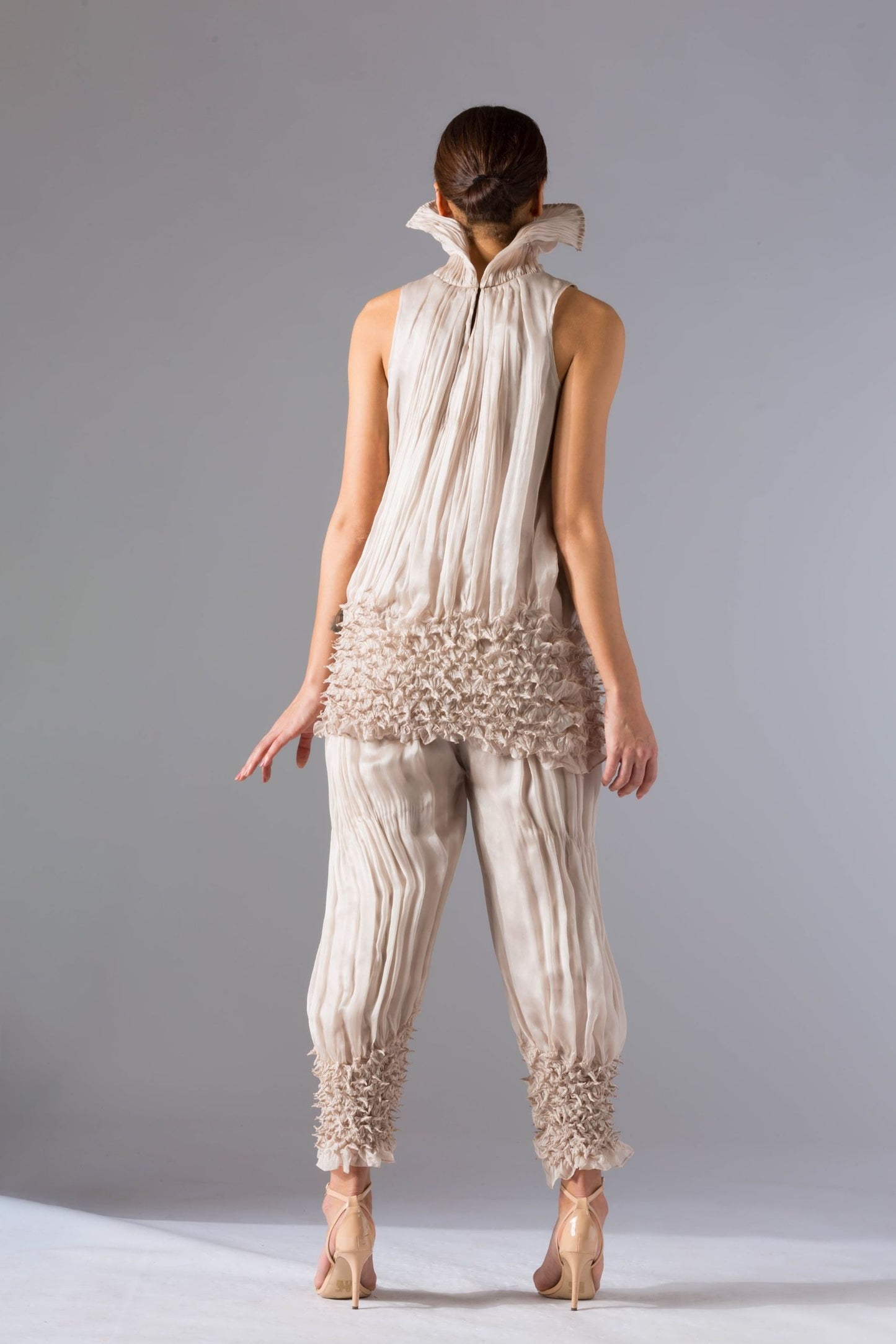 Back view of the women's top pant set, showcasing the fit of the drop-waist top and sculpted narrow pants