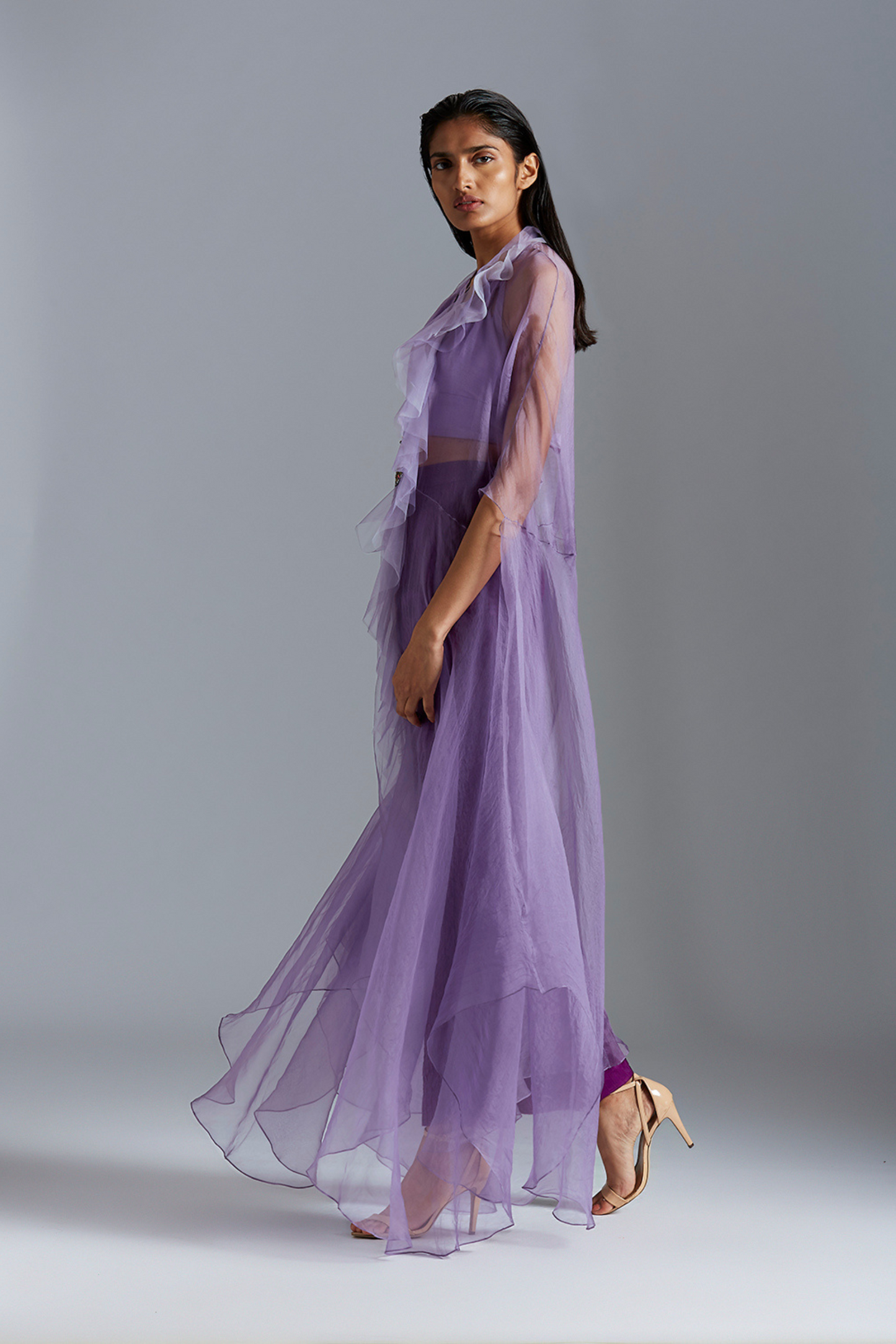 Side view of the cape with satin pintuck pants, showcasing the graceful silhouette and stylish fit