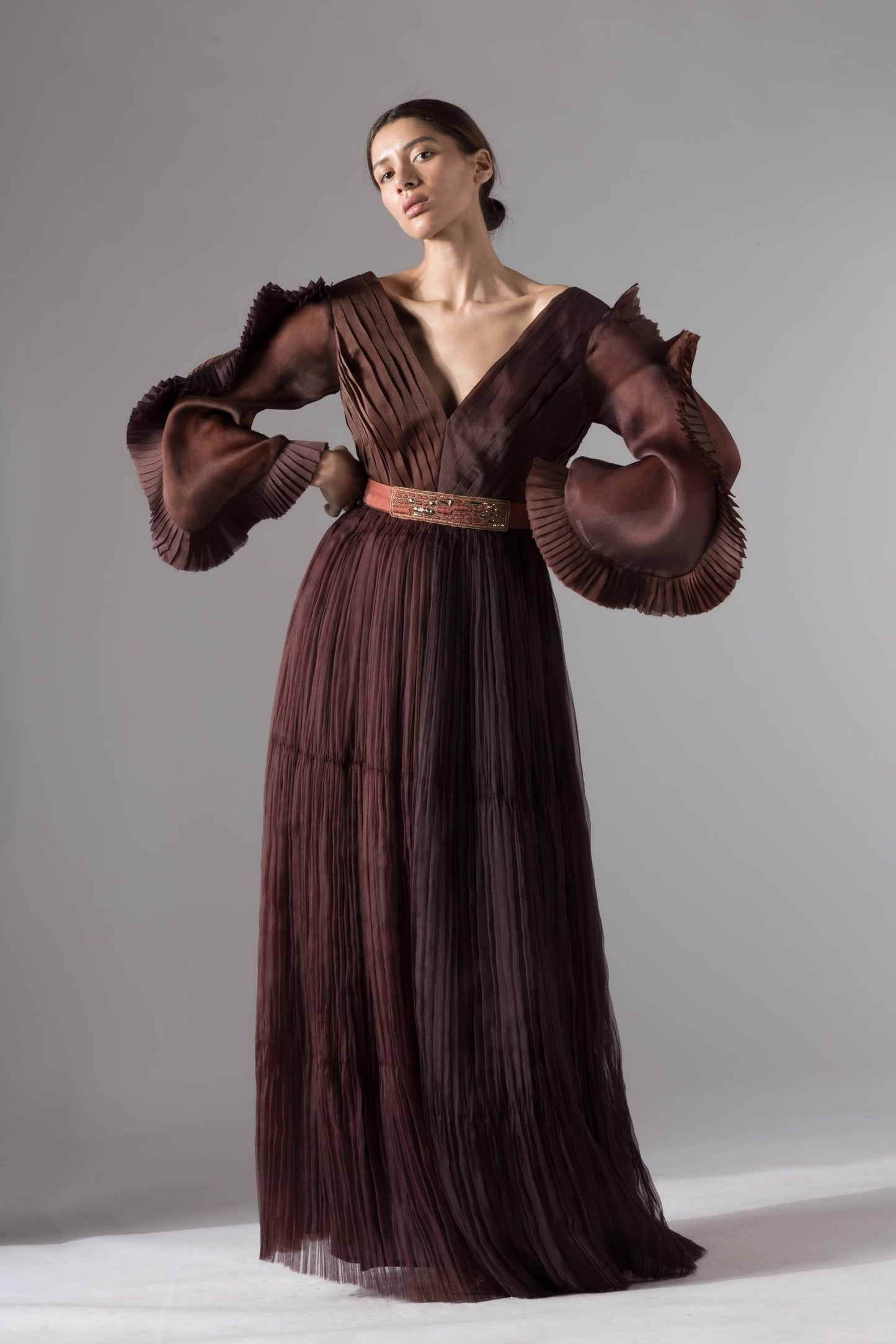 Elegant evening gown with pleated ruching, statement sleeves, and rope-inlay belt, offering a sophisticated and stylish look for evening events