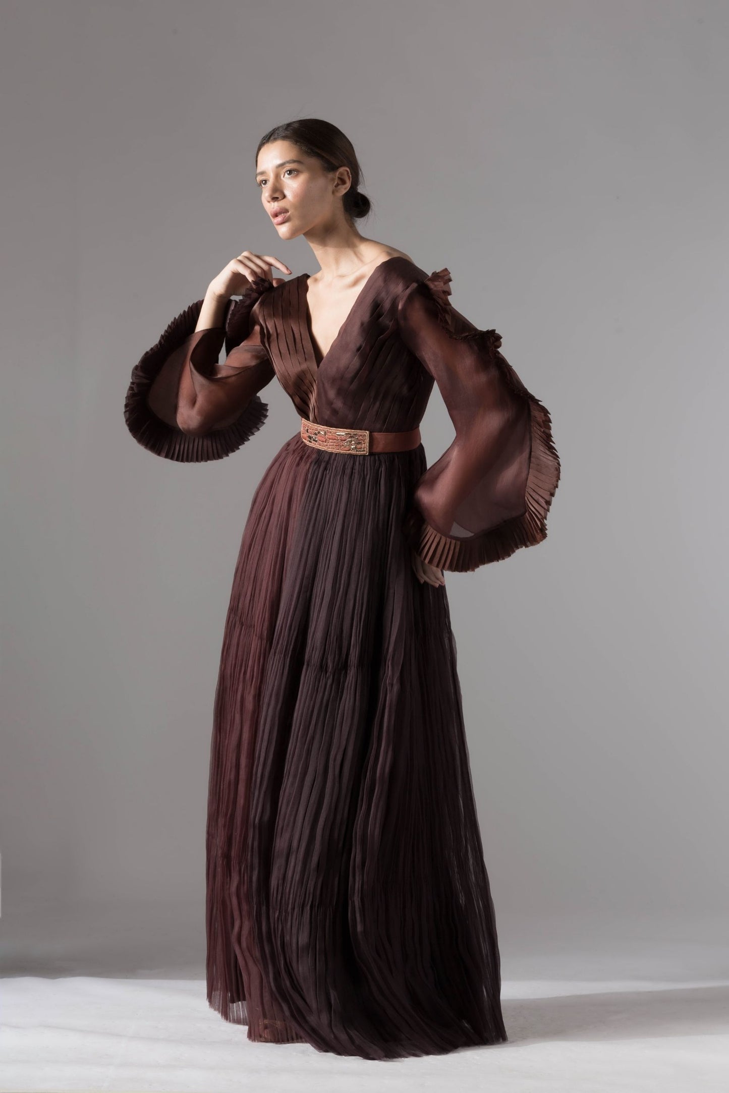 Elegant evening gown featuring pleated ruching, statement sleeves, and rope-inlay belt, perfect for chic and sophisticated evening events