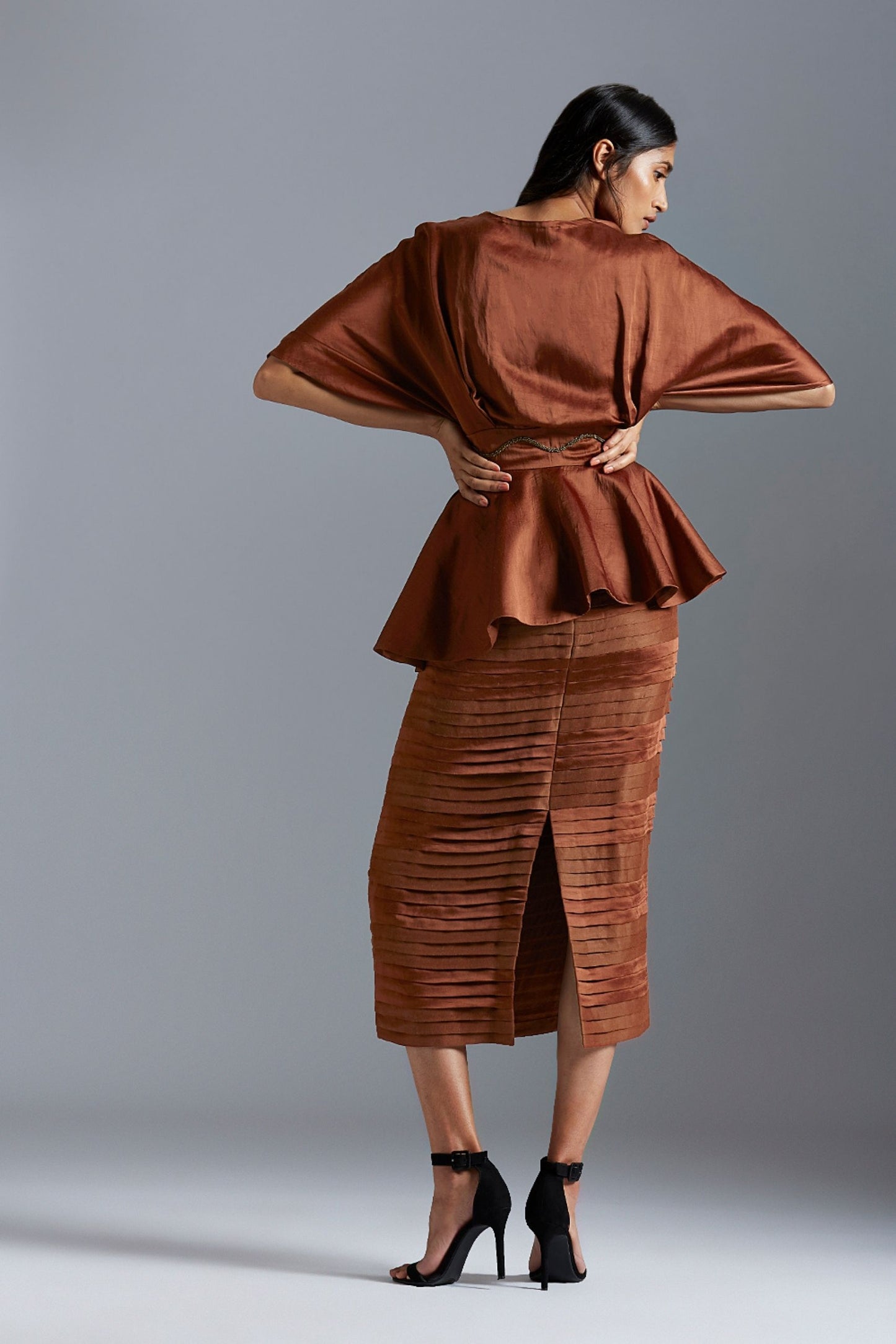 Back view of the kimono sleeve top and pleated skirt set, emphasizing the elegant cut and detailed embroidery