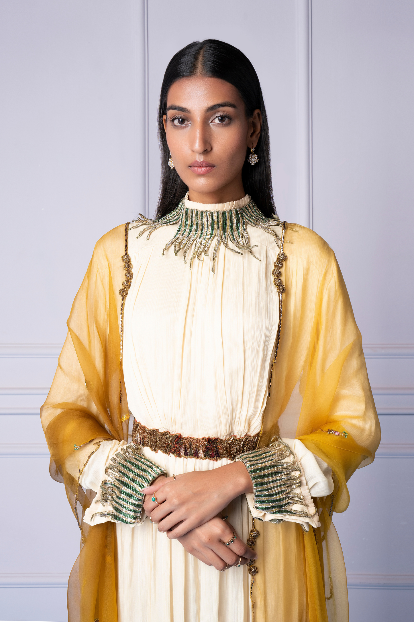 Close-up of the embroidered dupatta and metallic belt detail on the ivory gown