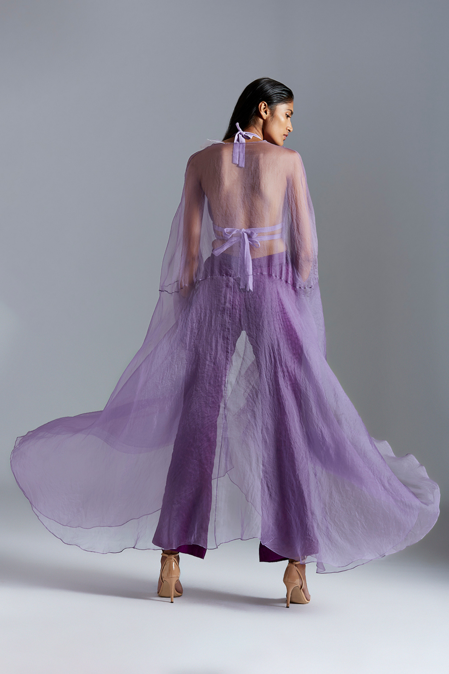 Back view of the elegant cape with satin pants, highlighting the sleek design and detailed craftsmanship