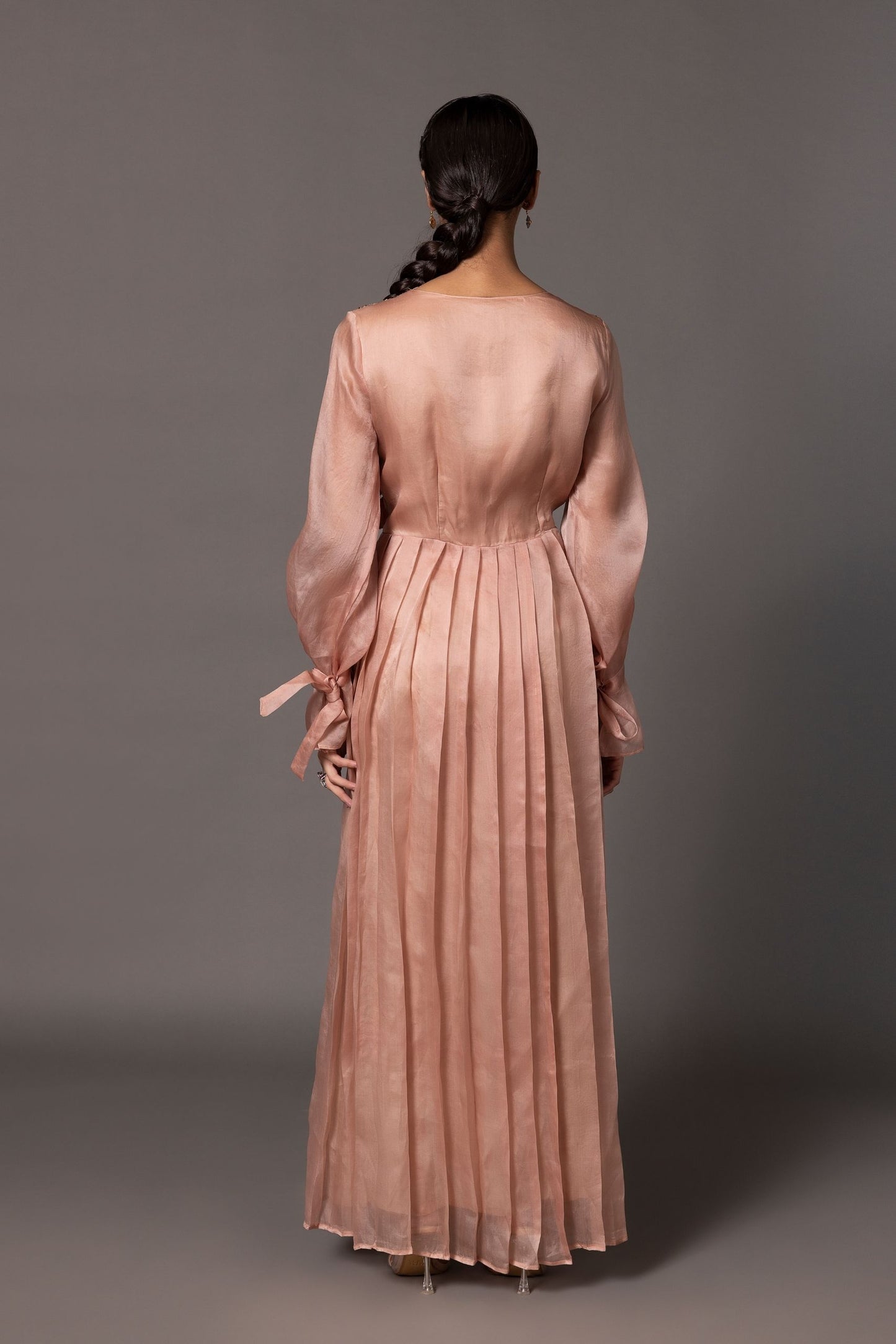 Back view of the Mima Mounds Pink Gown, showcasing the overall design and pleating details from behind